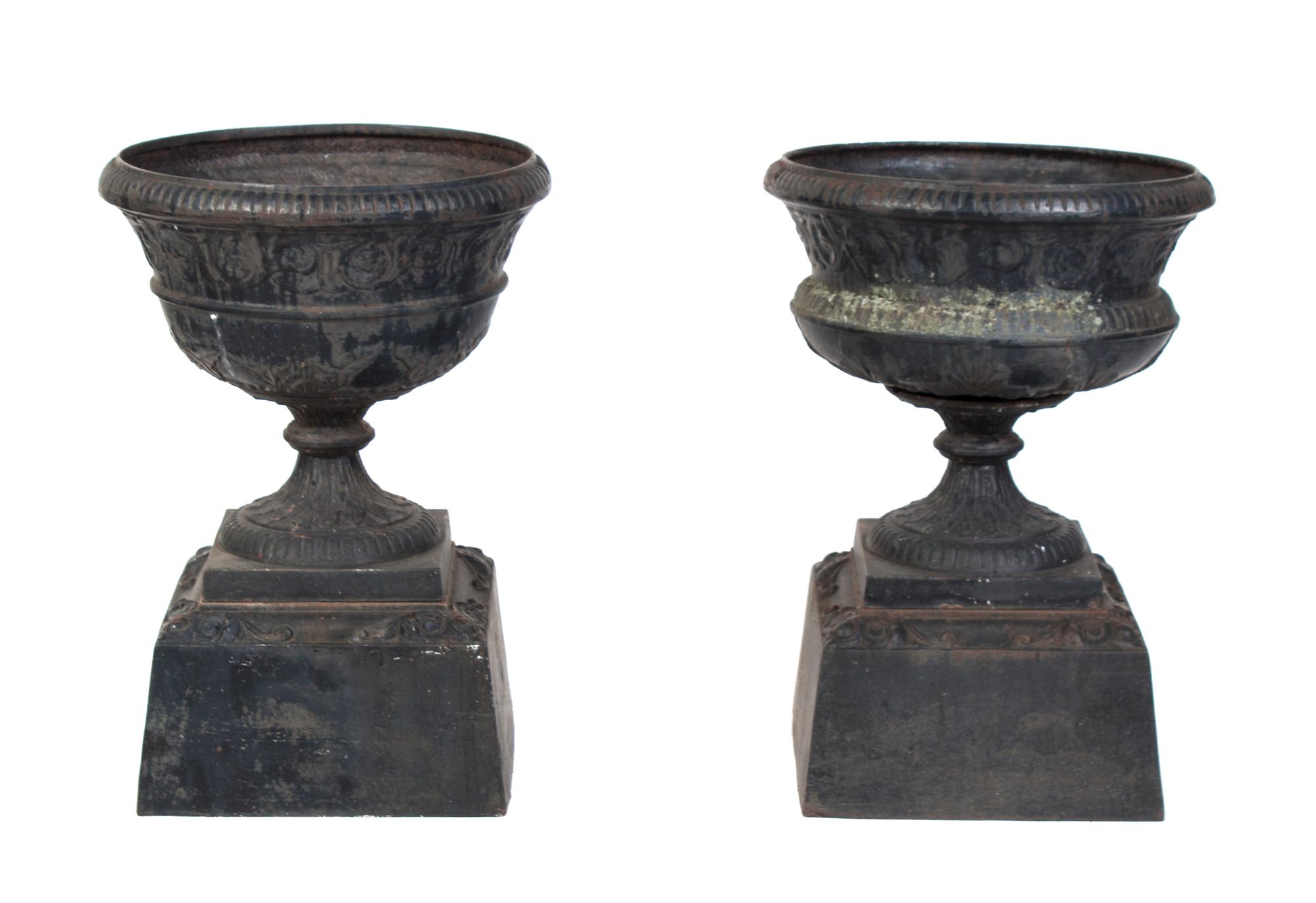 A Pair of Cast Iron Garden Urns Height 21 inches.