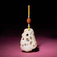 A Chinese Russet and White Jade Reticulated 'Lotus' Pendant, 18th/19th Century — 清中期 白玉帶皮鏤雕蓮紋佩