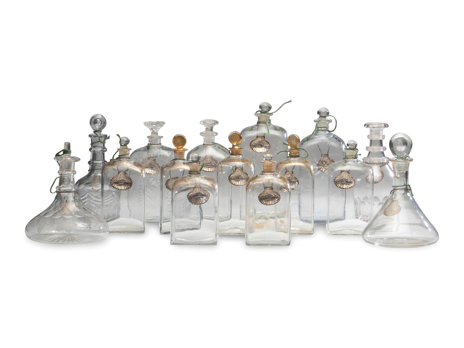 Fifteen Glass Decanters with English Shell-Form Silver Bottle Tags