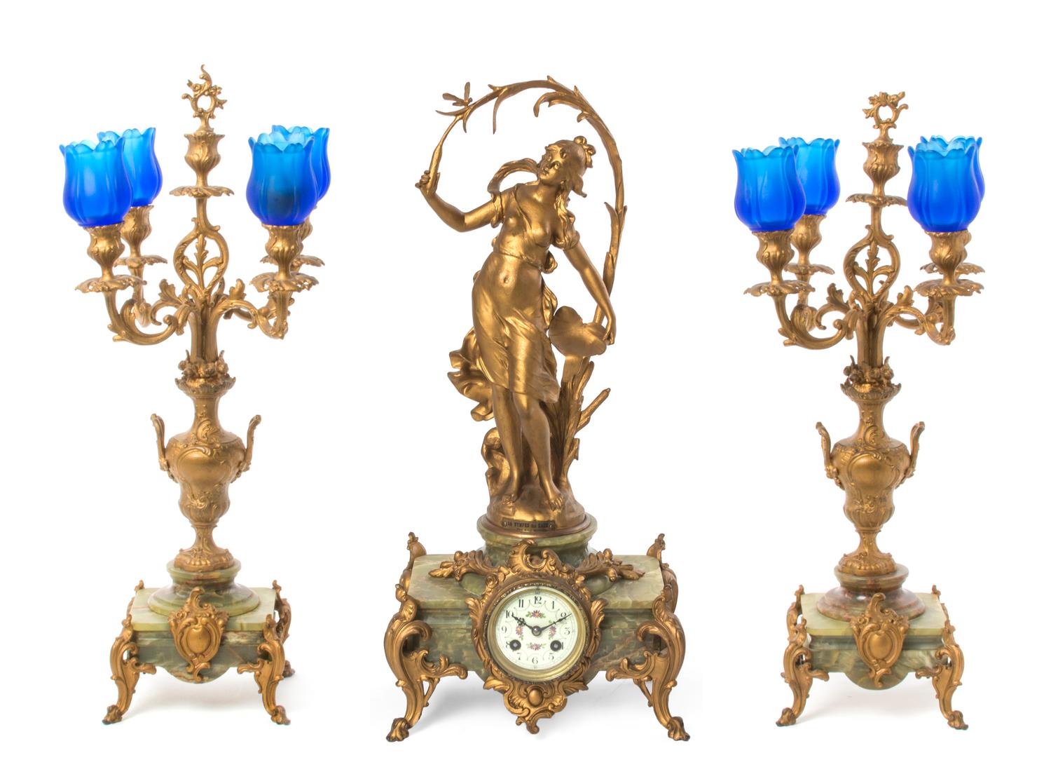 A Late Victorian Gilt Metal and Onyx Clock Garniture, after Auguste Moreau, Height of clock 23 1/4 inches.