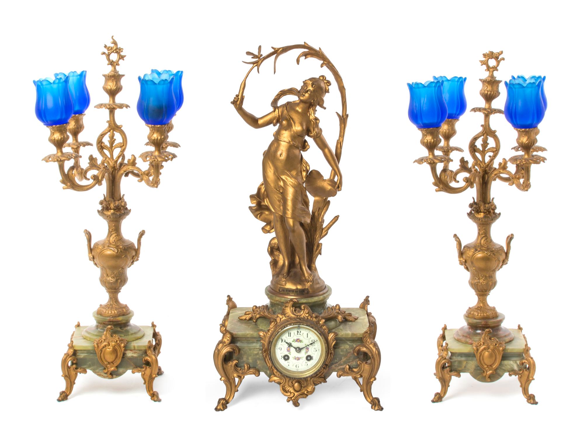 A Late Victorian Gilt Metal and Onyx Clock Garniture, after Auguste Moreau, Height of clock 23 1/4 inches.