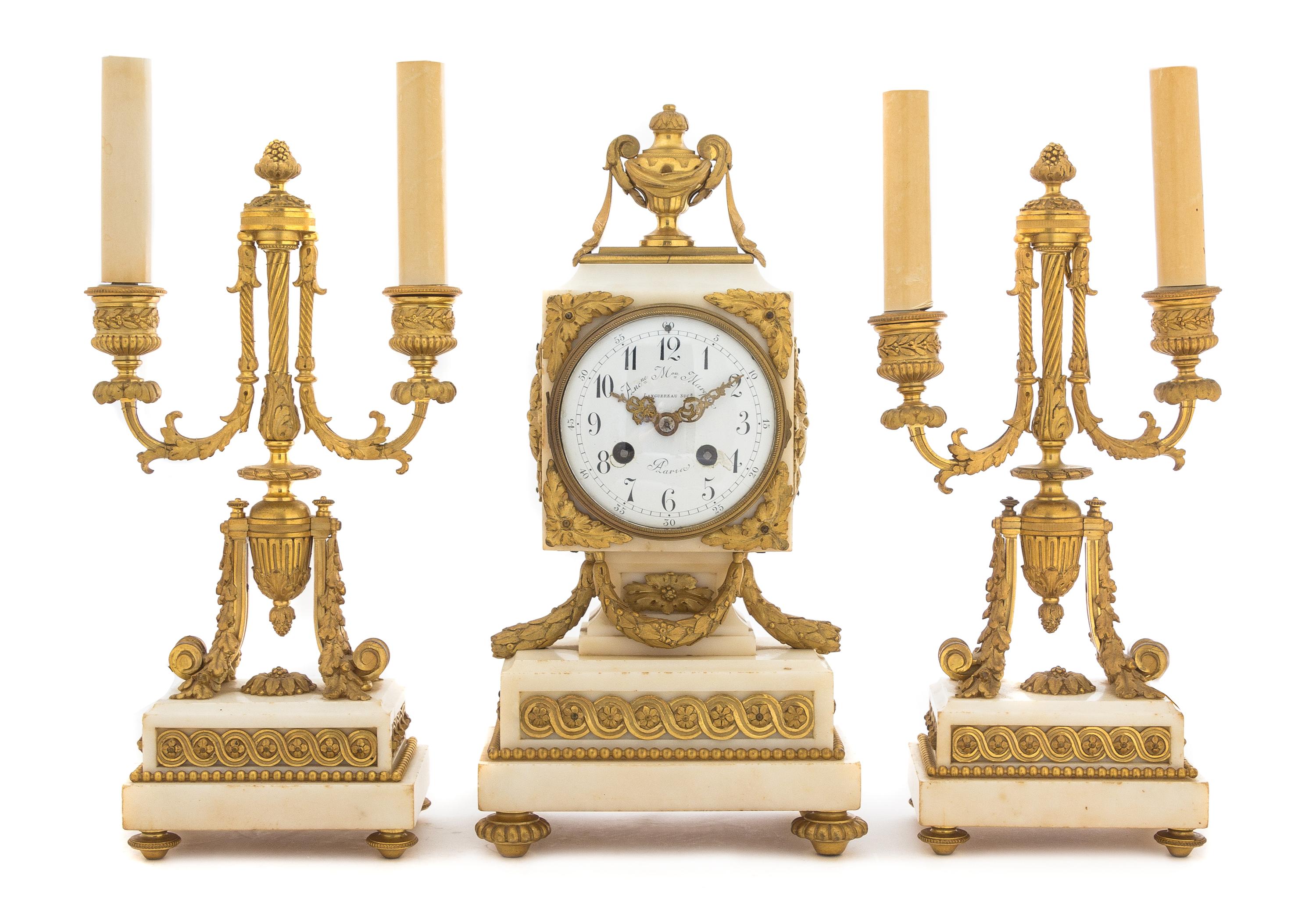 A French Gilt Bronze and Marble Three-Piece Clock Garniture Height of candelabra 16 3/4 inches. — MAISON MARQUIS, LANGUEREAU, PARIS, 19TH CENTURY