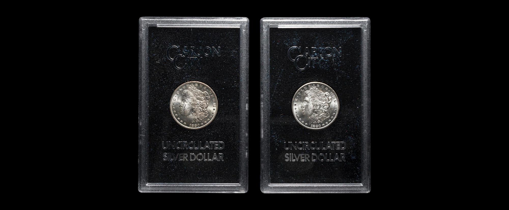 A Group of Two 1880-CC GSA: Morgan $1 Coins