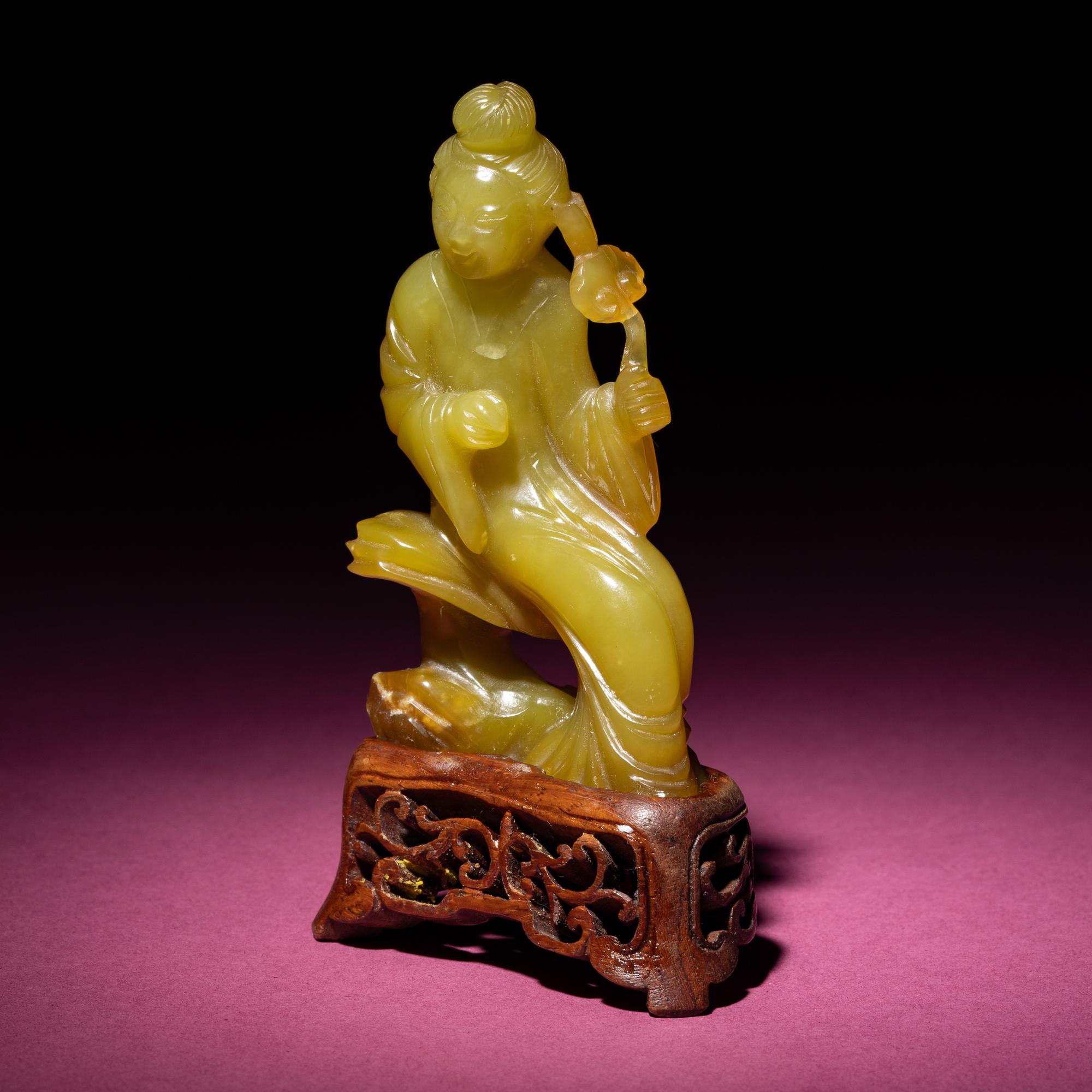 A Chinese Yellow Jade Seated Figure of a Lady, Late Qing Dynasty — 清晚期 黃玉持蓮仕女
