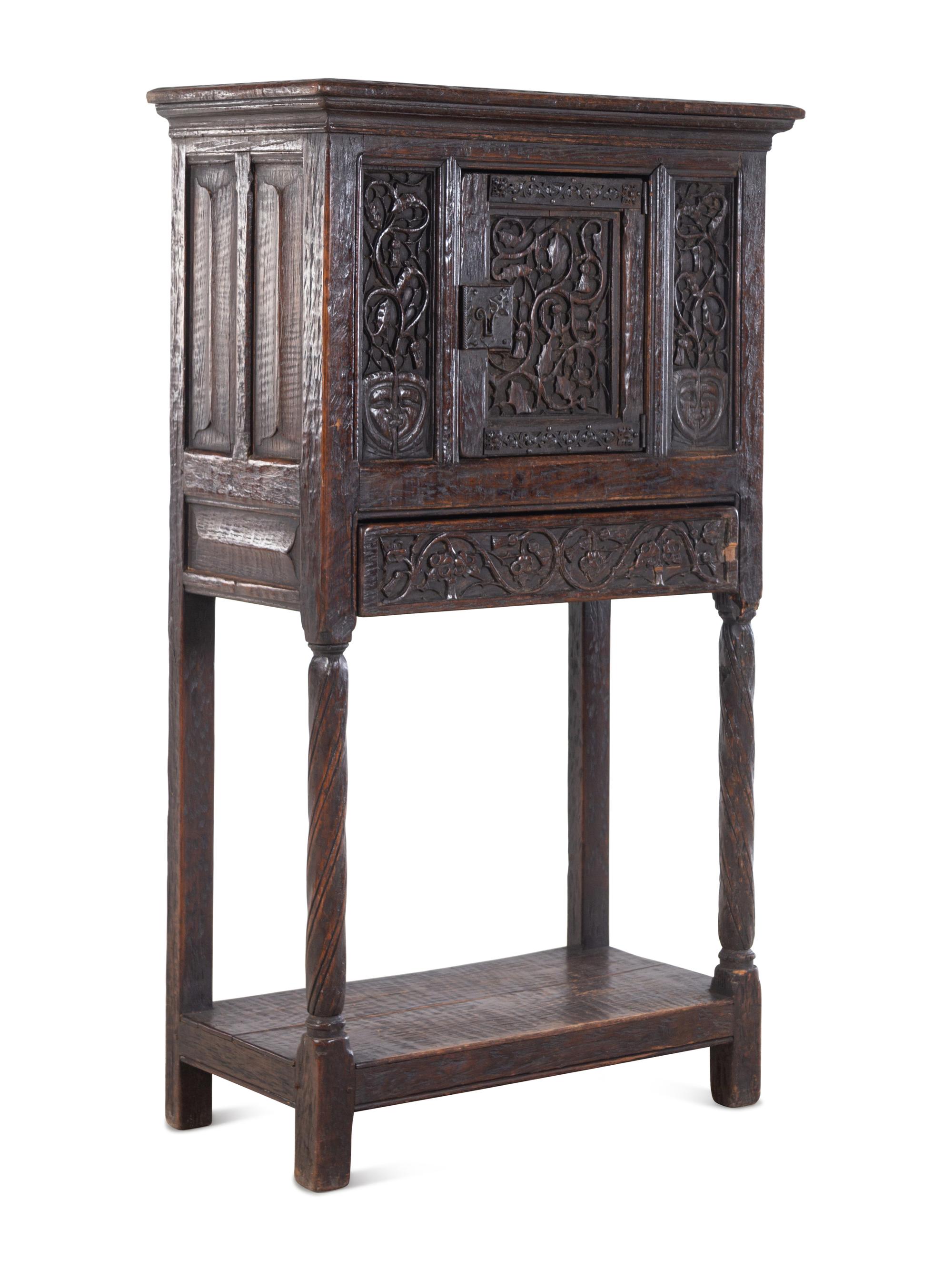 A Gothic Revival Carved Oak Cabinet on Stand