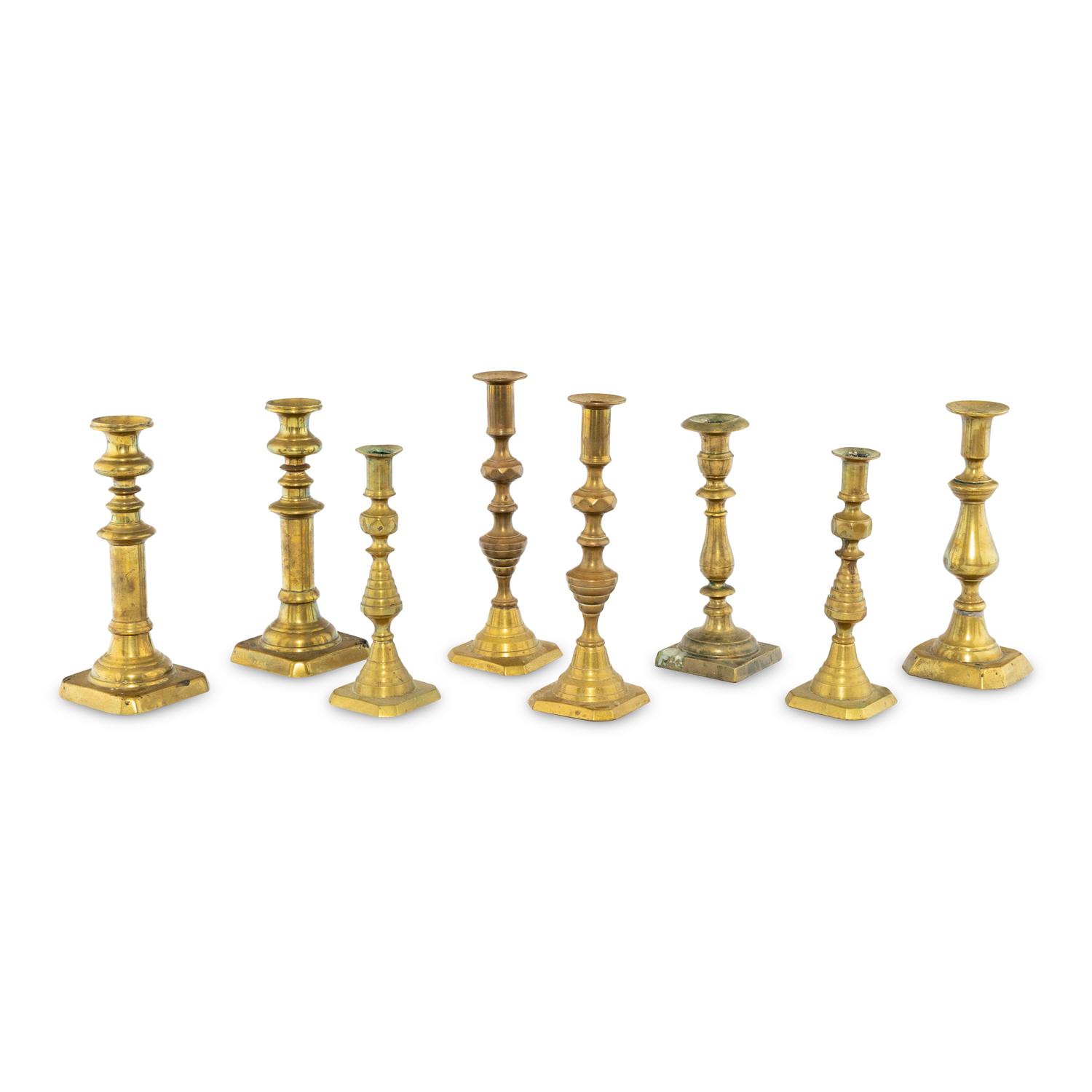 A Collection of Eight Continental Brass Candlesticks