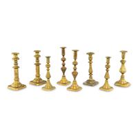 A Collection of Eight Continental Brass Candlesticks