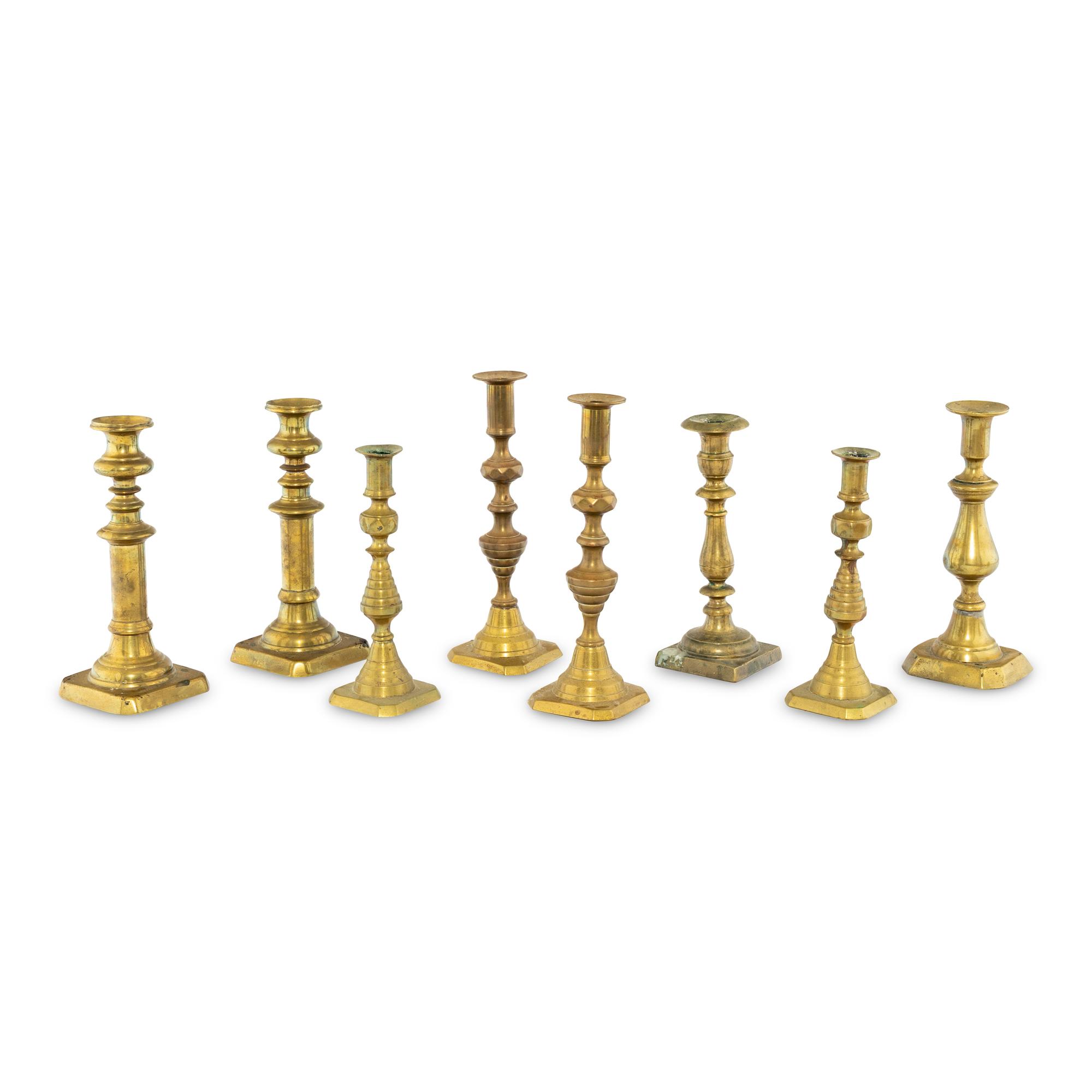 A Collection of Eight Continental Brass Candlesticks