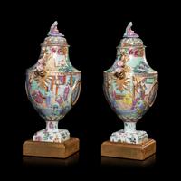 A Pair of Chinese Export Canton Famille Rose Porcelain Covered Urns, Early 19th Century — 清晚期 外銷廣彩人物故事圖獎杯形賞瓶一對