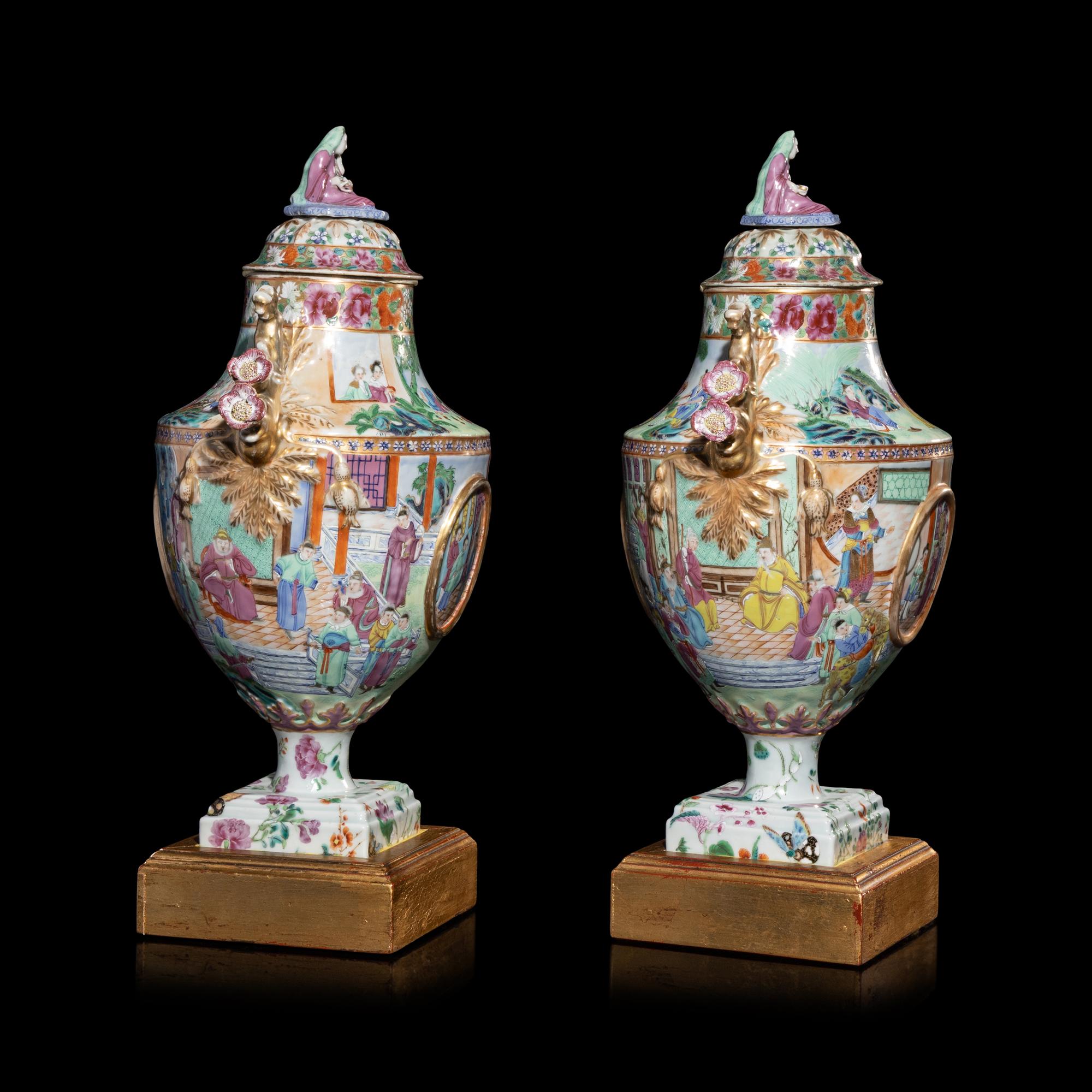A Pair of Chinese Export Canton Famille Rose Porcelain Covered Urns, Early 19th Century — 清晚期 外銷廣彩人物故事圖獎杯形賞瓶一對