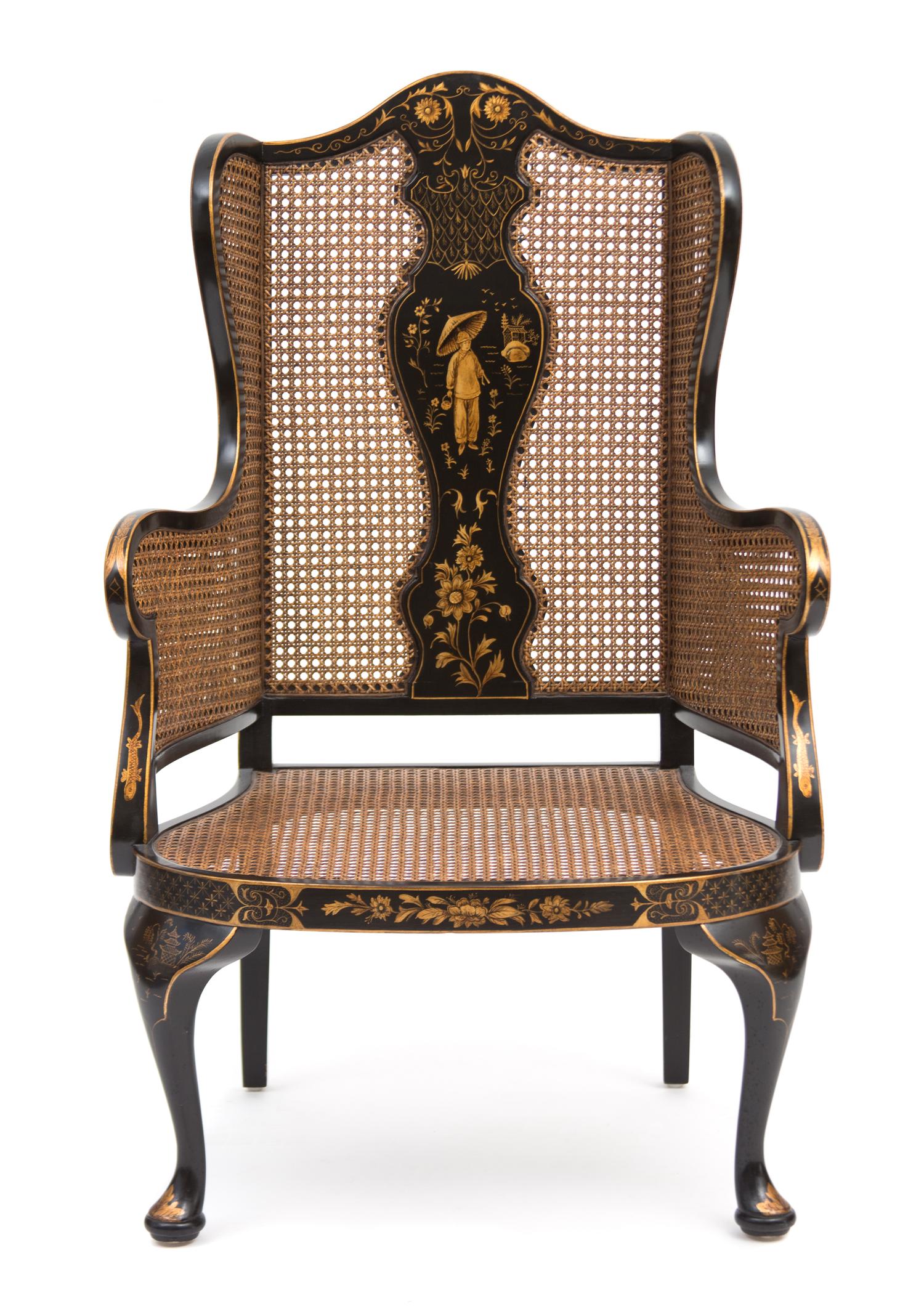 A Regency Style Black and Gilt Chinoiserie Decorated Caned Wing Chair Height 50 inches. — 20TH CENTURY