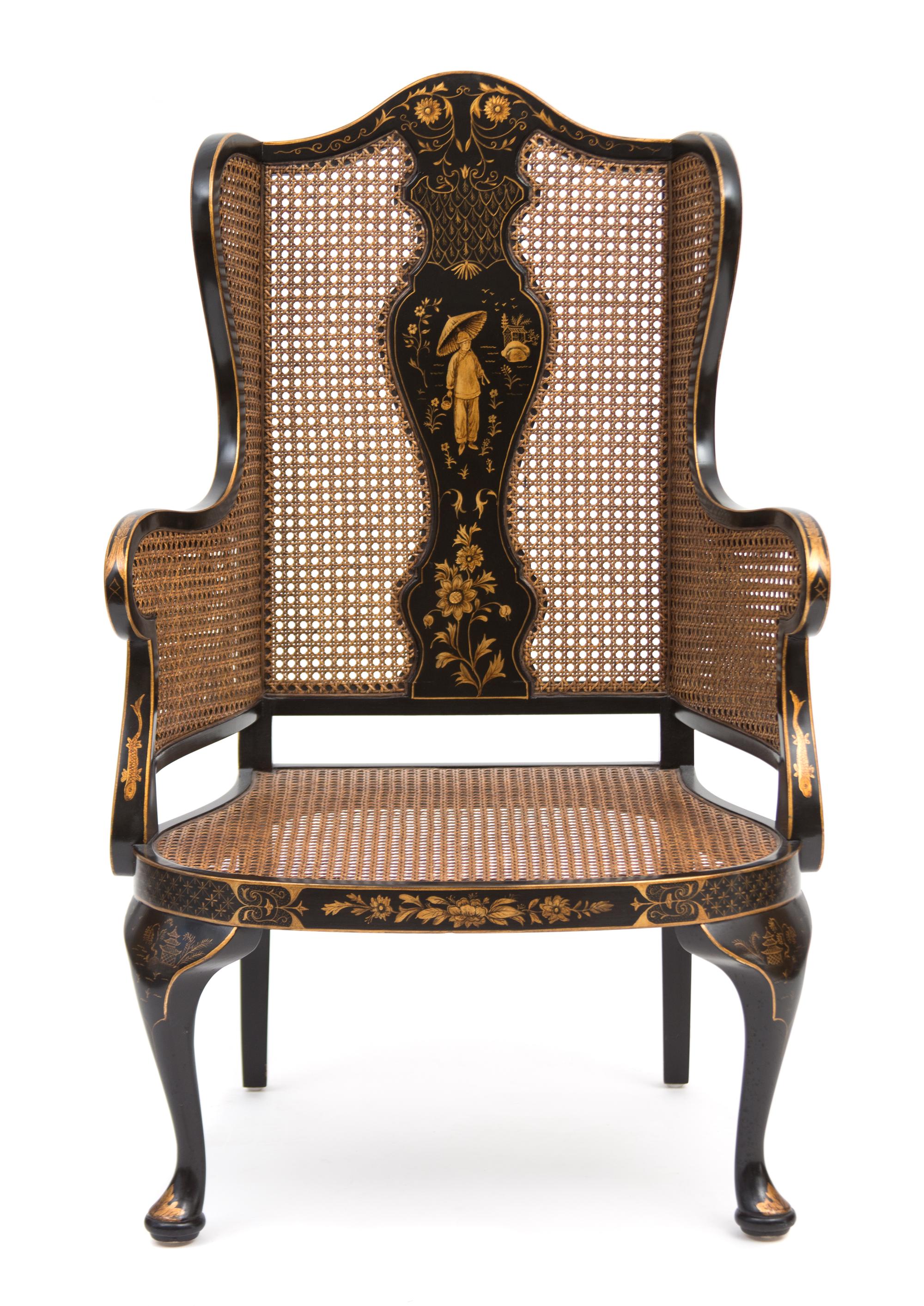 A Regency Style Black and Gilt Chinoiserie Decorated Caned Wing Chair Height 50 inches. — 20TH CENTURY