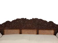 A British Colonial Carved Mahogany and Cane Work Settee