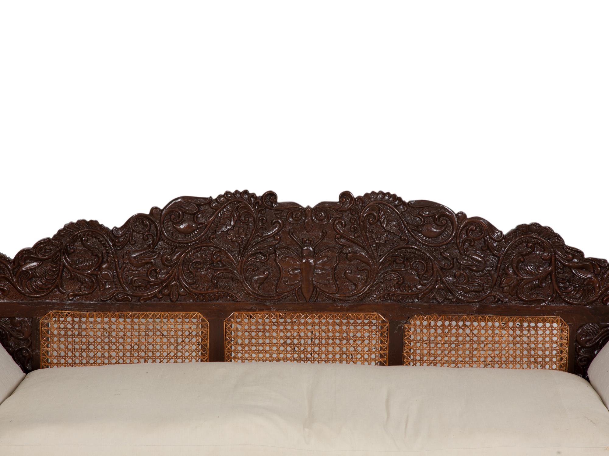 A British Colonial Carved Mahogany and Cane Work Settee