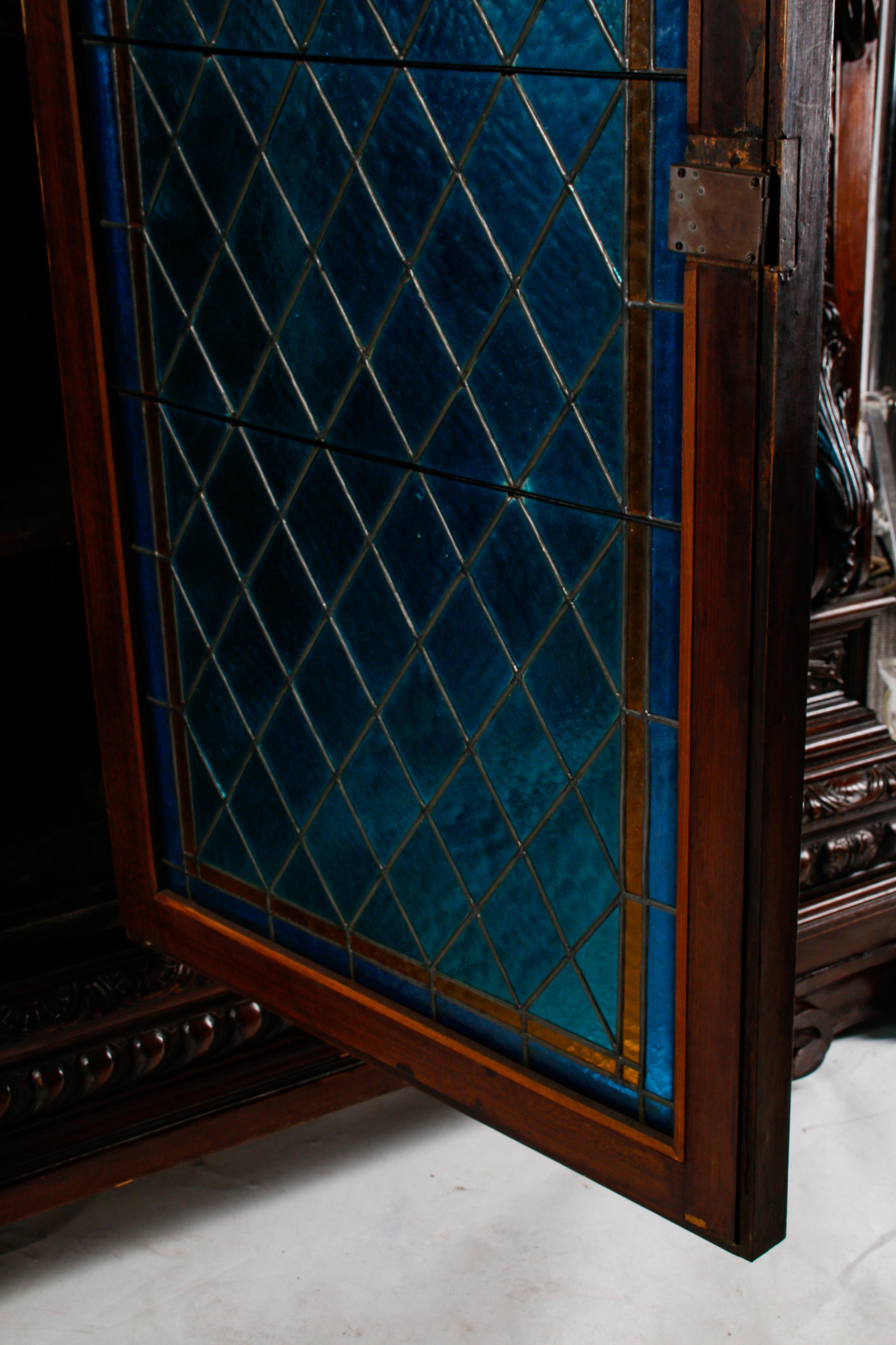 A Continental Renaissance Revival Carved Walnut and Leaded Glass Cabinet