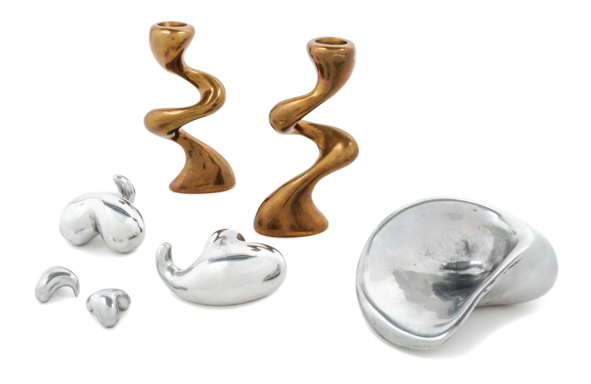 Jordan Mozer, (American, b.1958), a group of metal table articles comprising a pair of candlesticks, bowl and two decorative articles