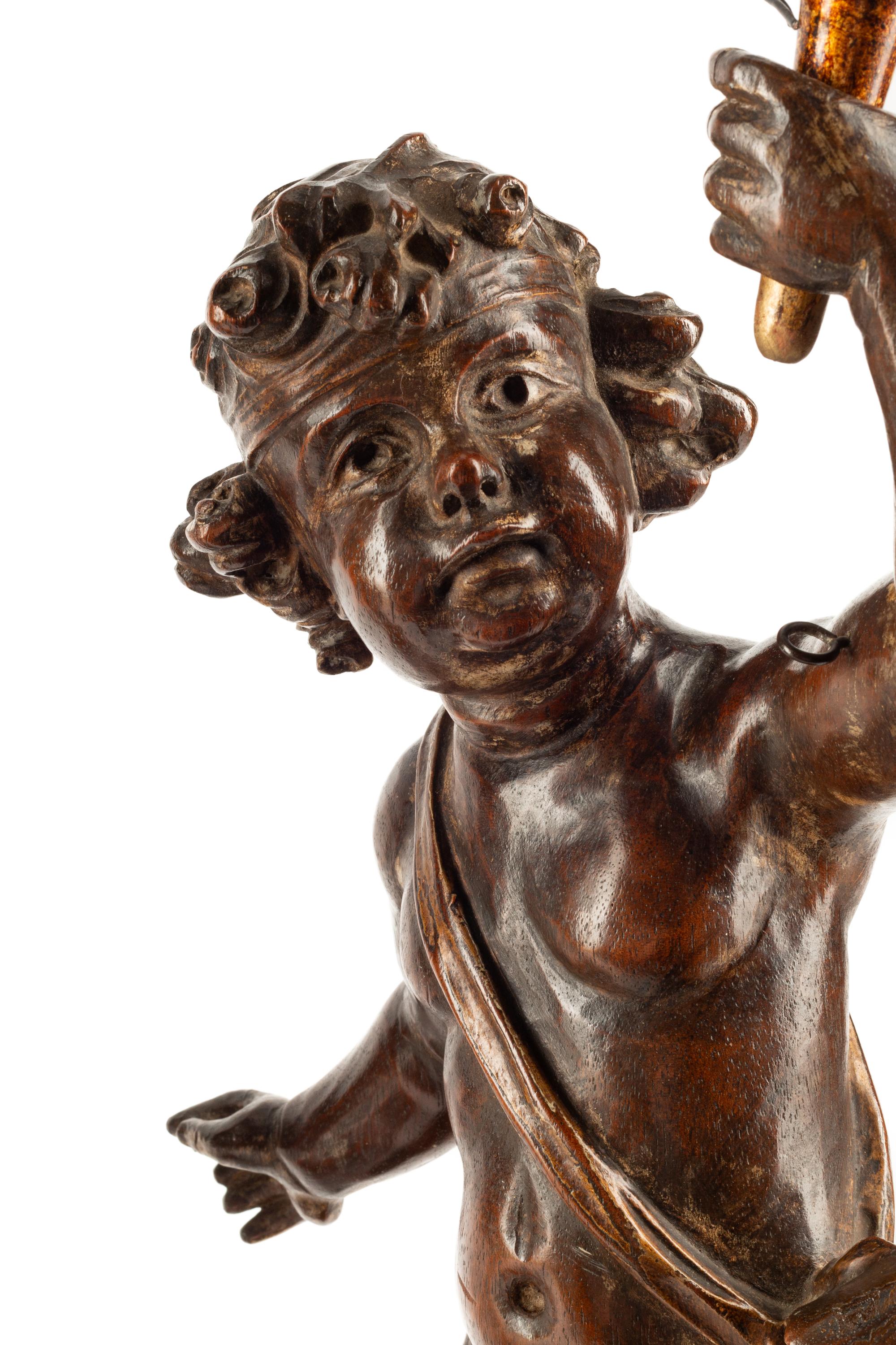 A Pair of Continental Carved Walnut Figures of Putti
