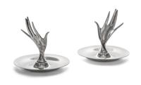 A Pair of American Silver Ring Trays, Tiffany & Co., New York, NY, each formed as a circular dish with a modernist hand rising from the