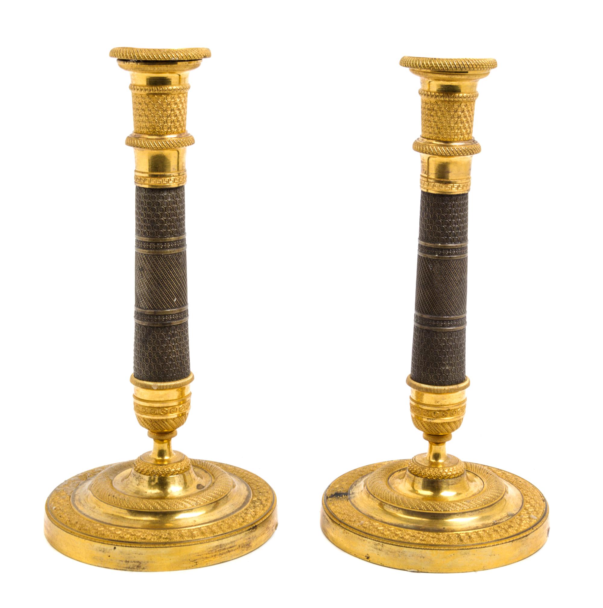A Pair of Empire Gilt and Patinated Bronze Candlesticks Height 10 3/4 inches. — 19TH CENTURY