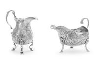 An Irish Silver Creamer and Sauce Boat, Maker's Marks Obscured, Dublin, each having scroll handles, the bodies worked with repousee flo