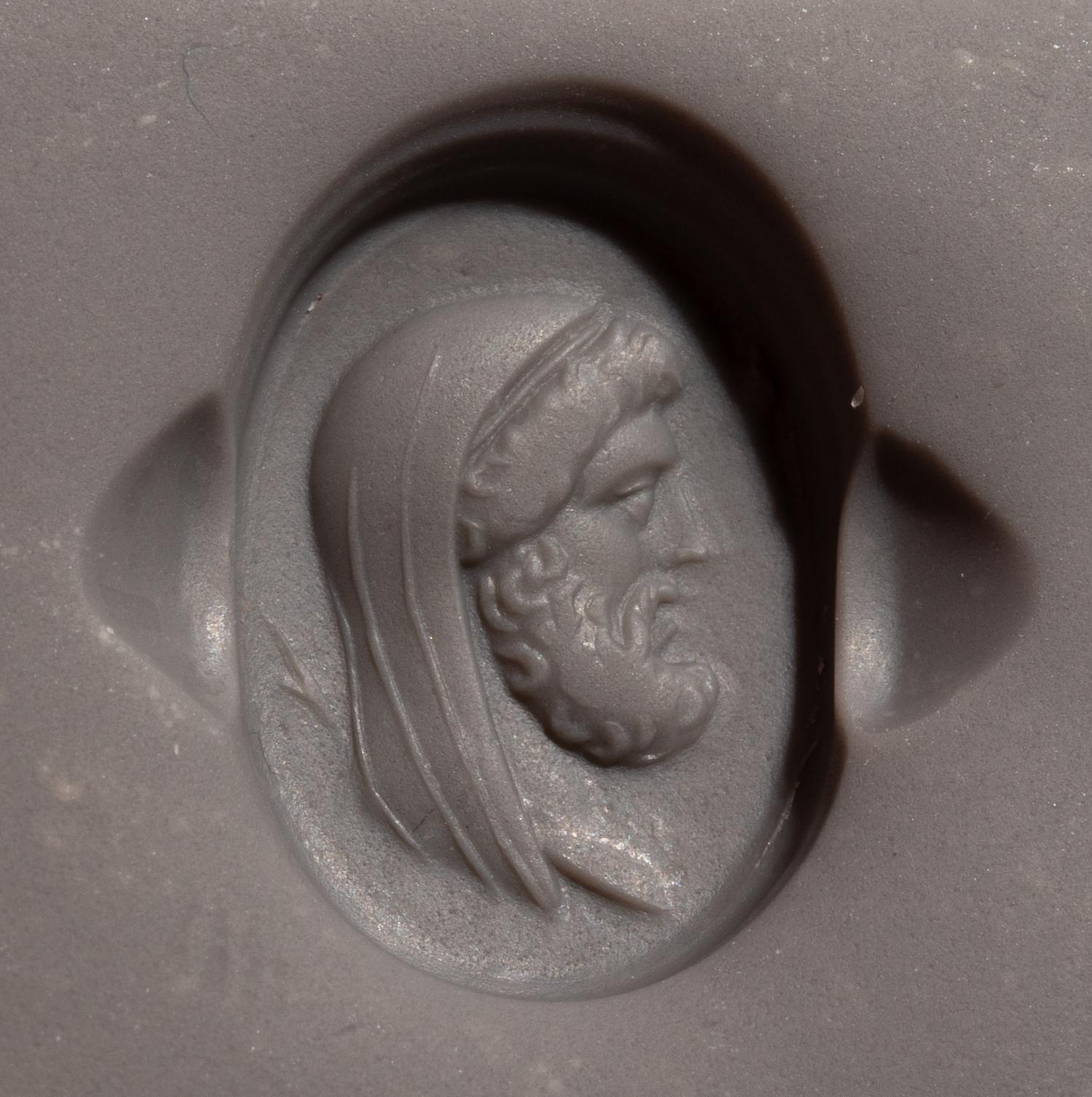 A Roman Carnelian Ring Stone with a Portrait Head of the God Cronus — Set in a gold ring