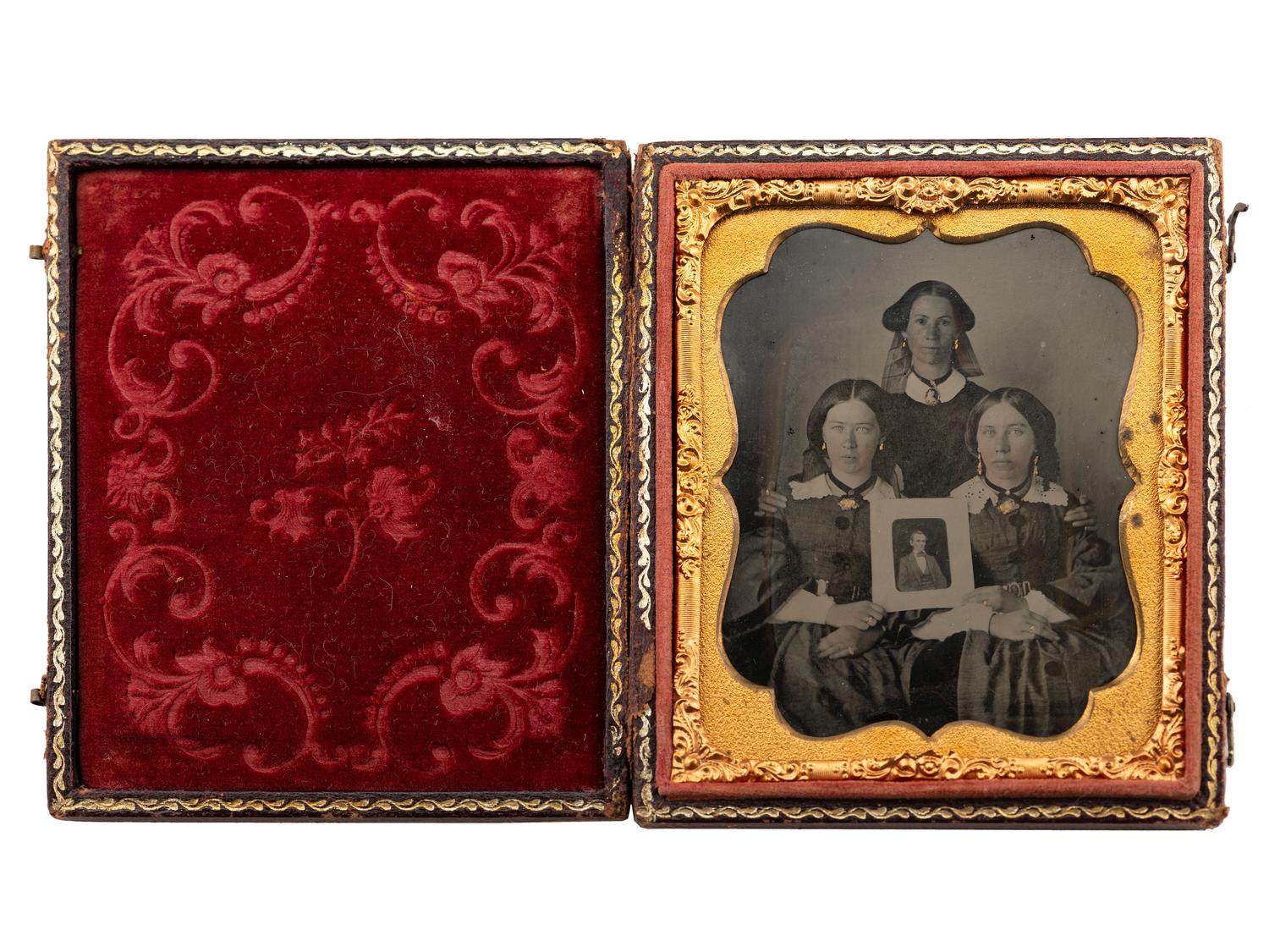 [LINCOLNIANA - EARLY PHOTOGRAPHY]. Sixth plate ambrotype of three patriotic women proudly displaying a portrait of Abraham Lincoln.