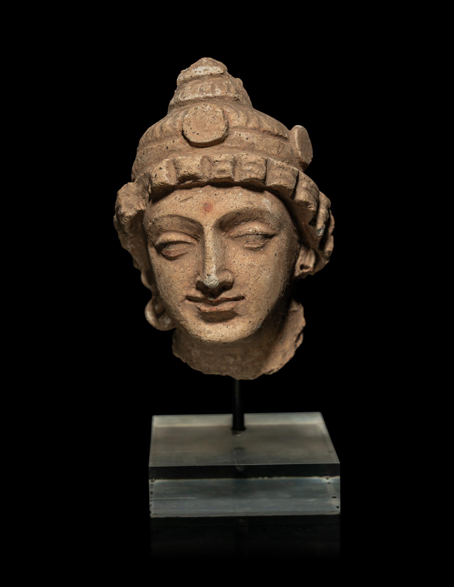 A Small Gandharan Polychromed Stucco Head of a Bodhisattva