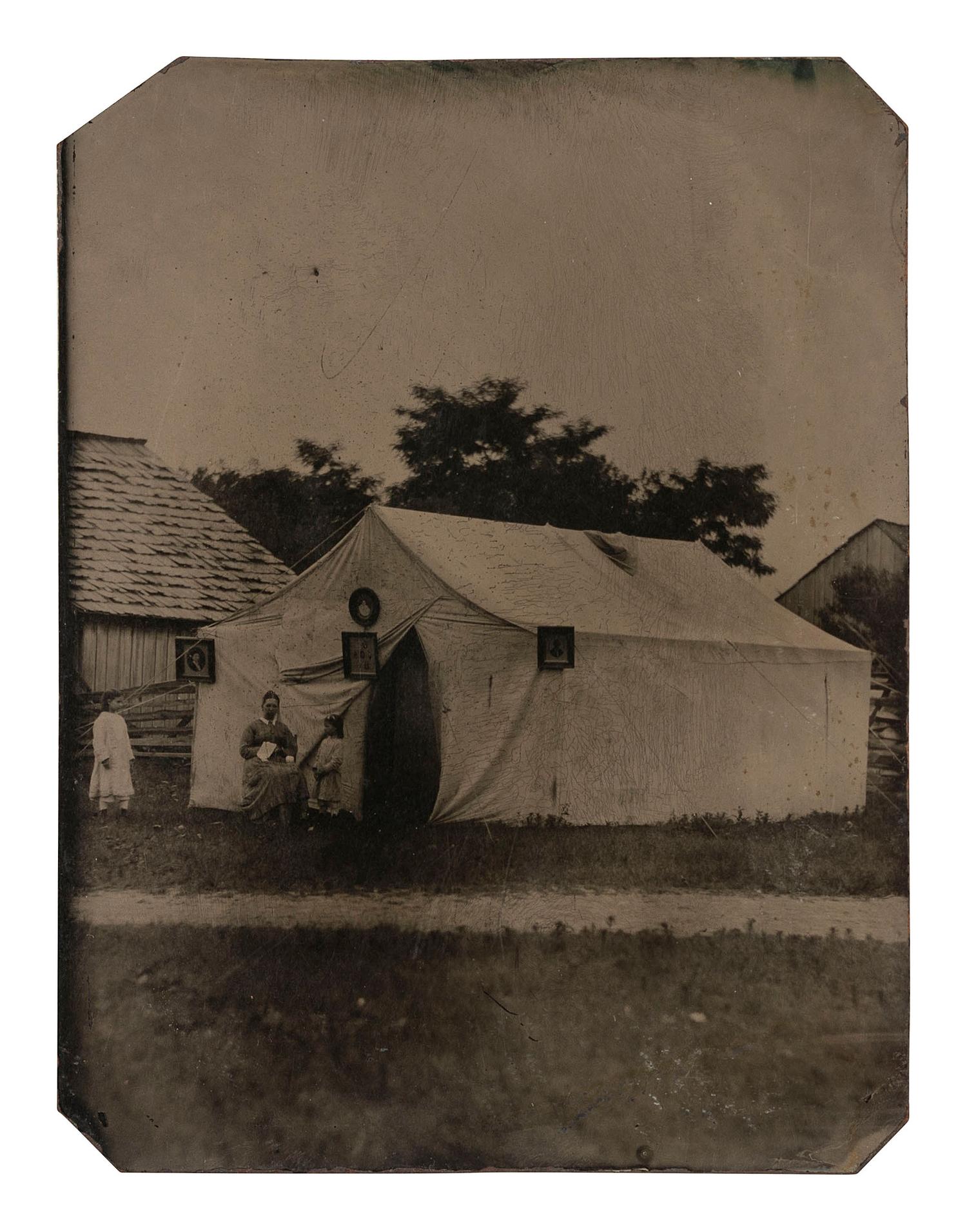 [EARLY PHOTOGRAPHY]. Tintype featuring a photographer's tent with example images displayed on the exterior.