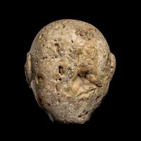 An Aztec Stone Head of the Deity Xipe Totec
