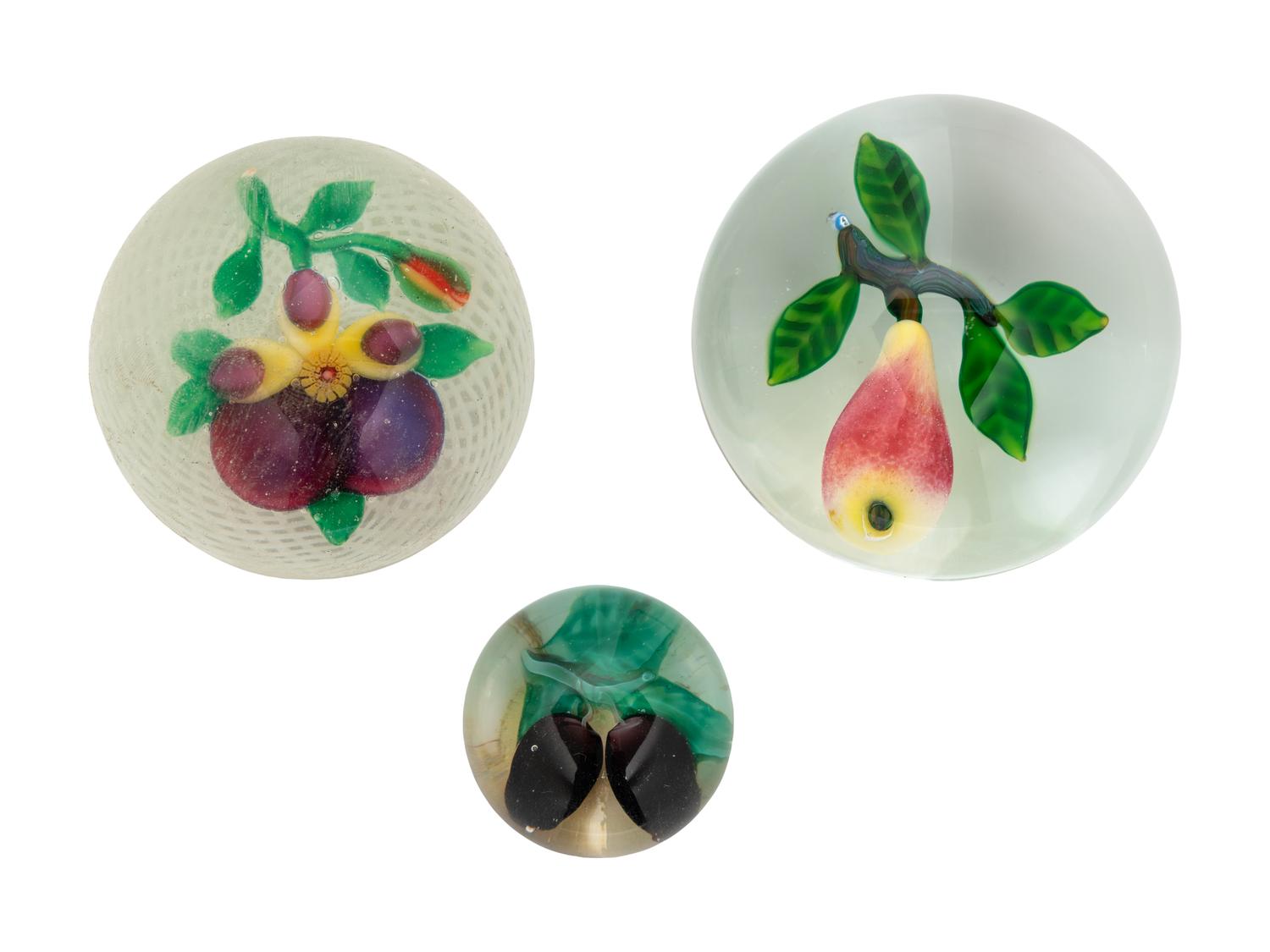 A Two Plums Glass Paperweight, a Chinese Pansy and Bud on Latticino Basket Glass Paperweight and a Pear Glass Paperweight