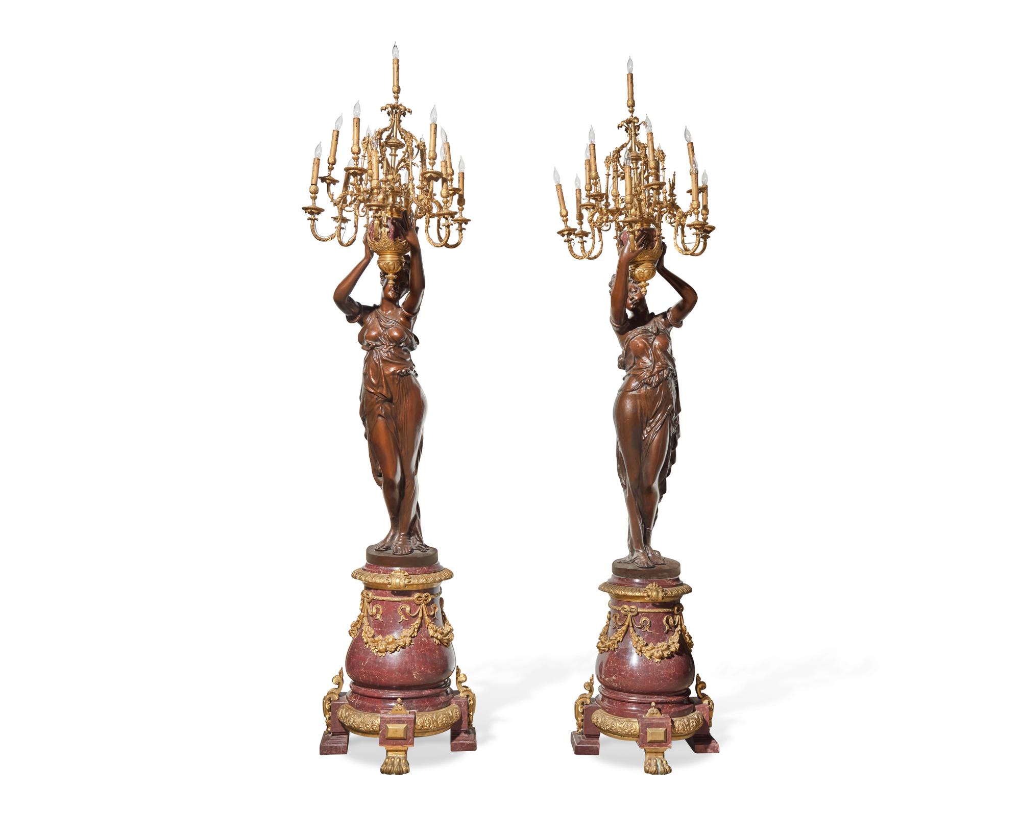 An impressive pair of large French gilt-bronze mounted bronze and rouge marble torchères, 20th century