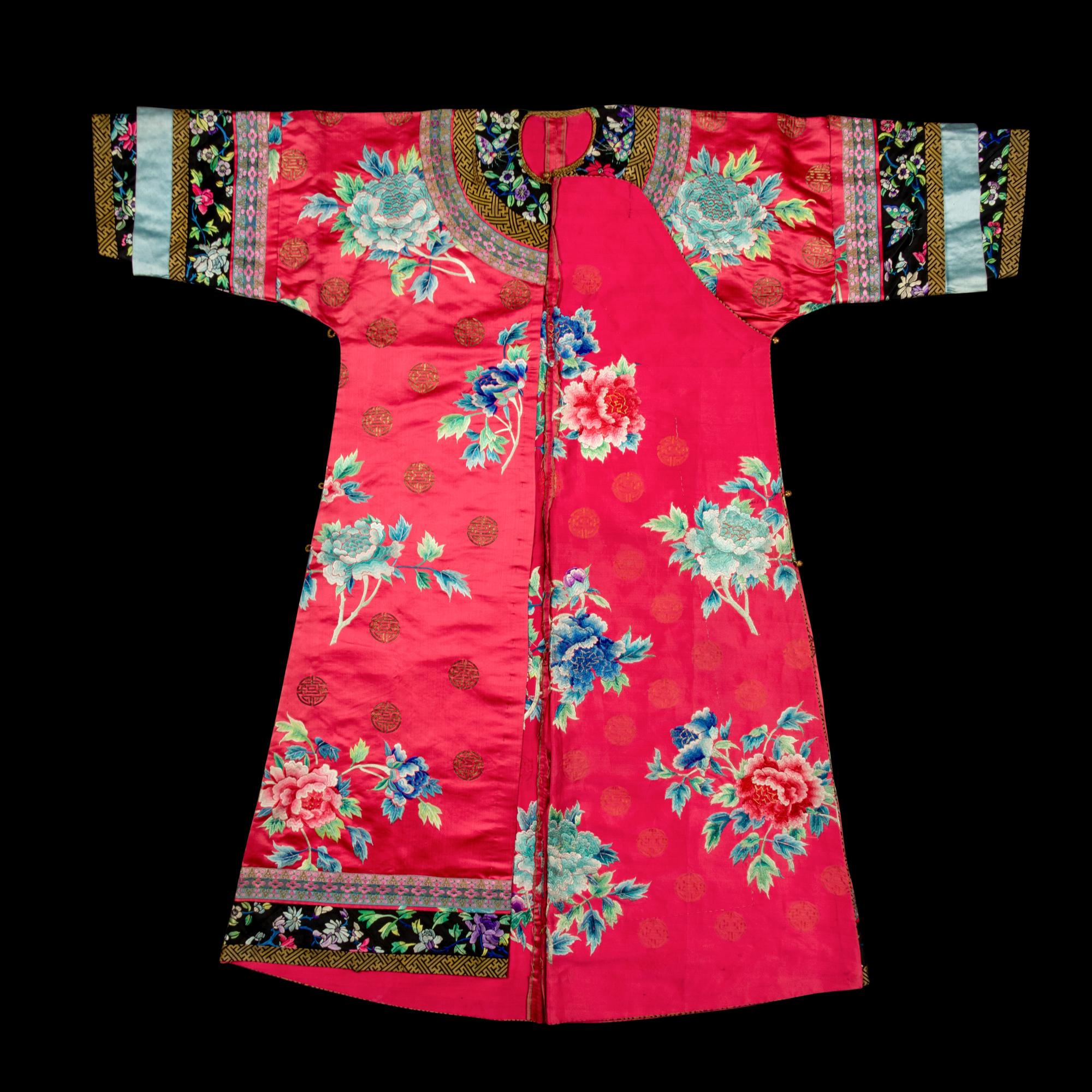 A Chinese Red Ground Embroidered Silk Manchu Lady's Informal Robe, Changyi, Late 19th Century 清晚期 桃紅緞綉牡丹團壽紋氅衣