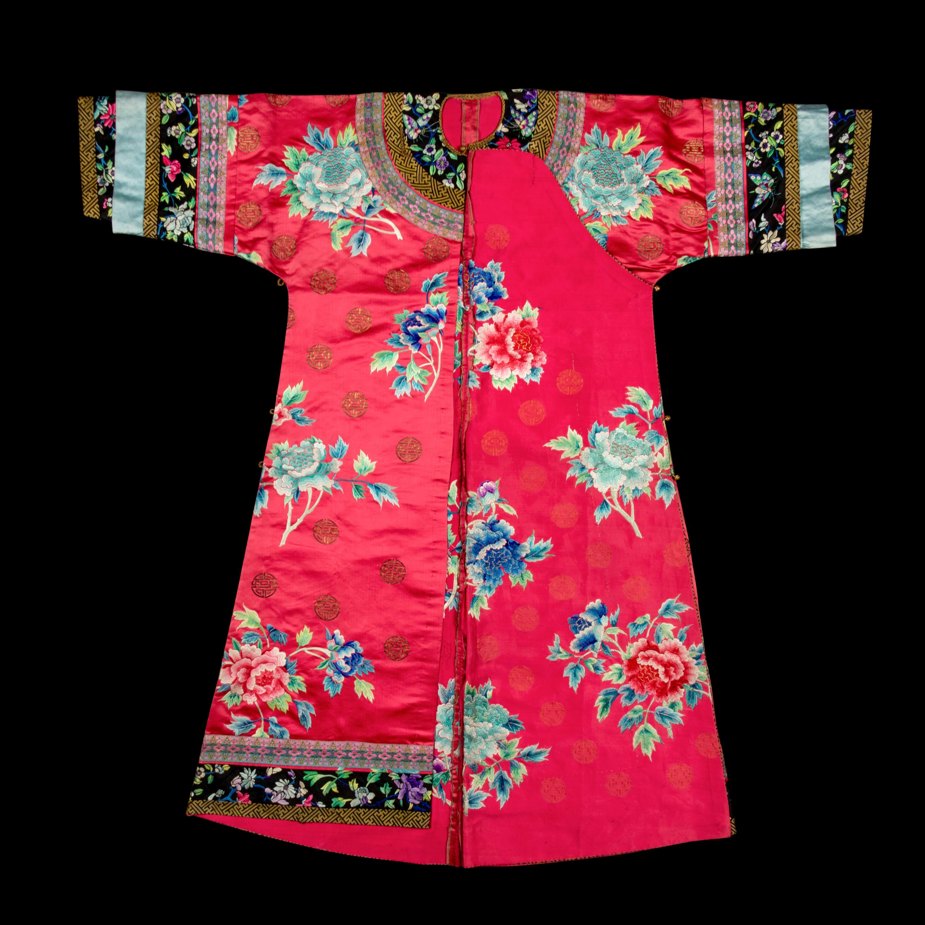 A Chinese Red Ground Embroidered Silk Manchu Lady's Informal Robe, Changyi, Late 19th Century 清晚期 桃紅緞綉牡丹團壽紋氅衣