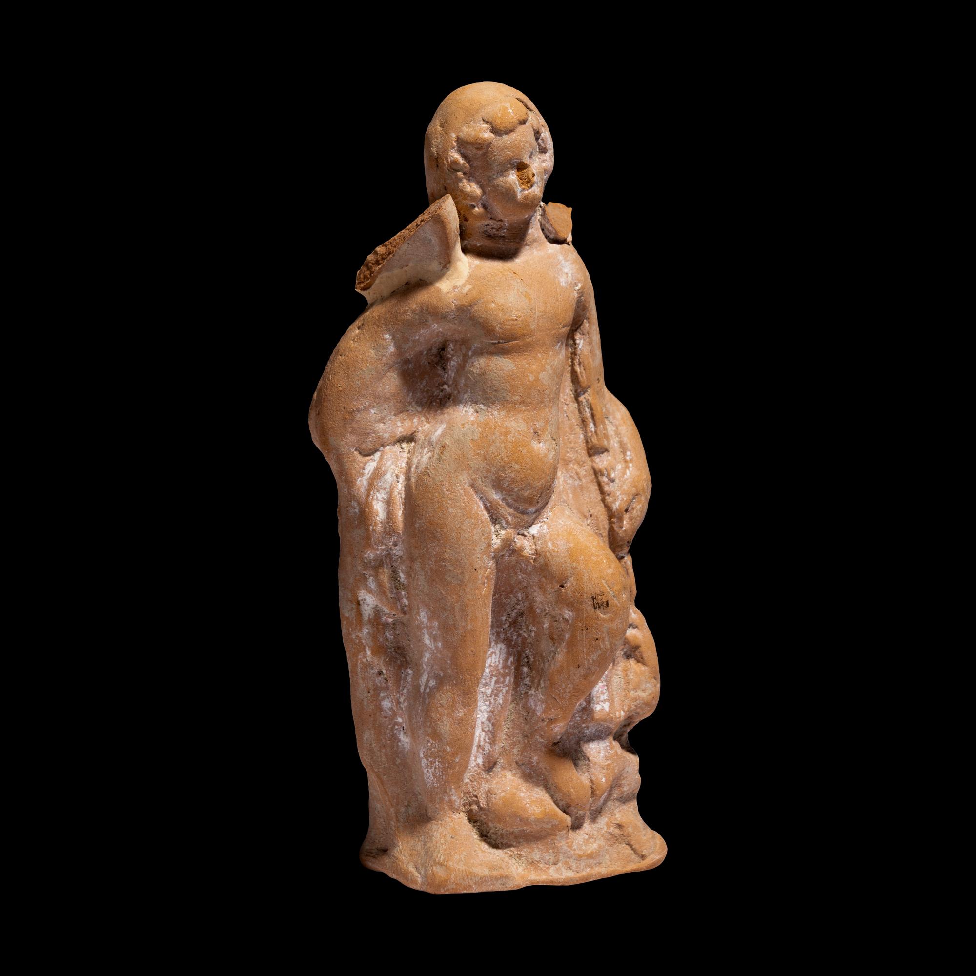 A Greek Terracotta Eros Holding a Club