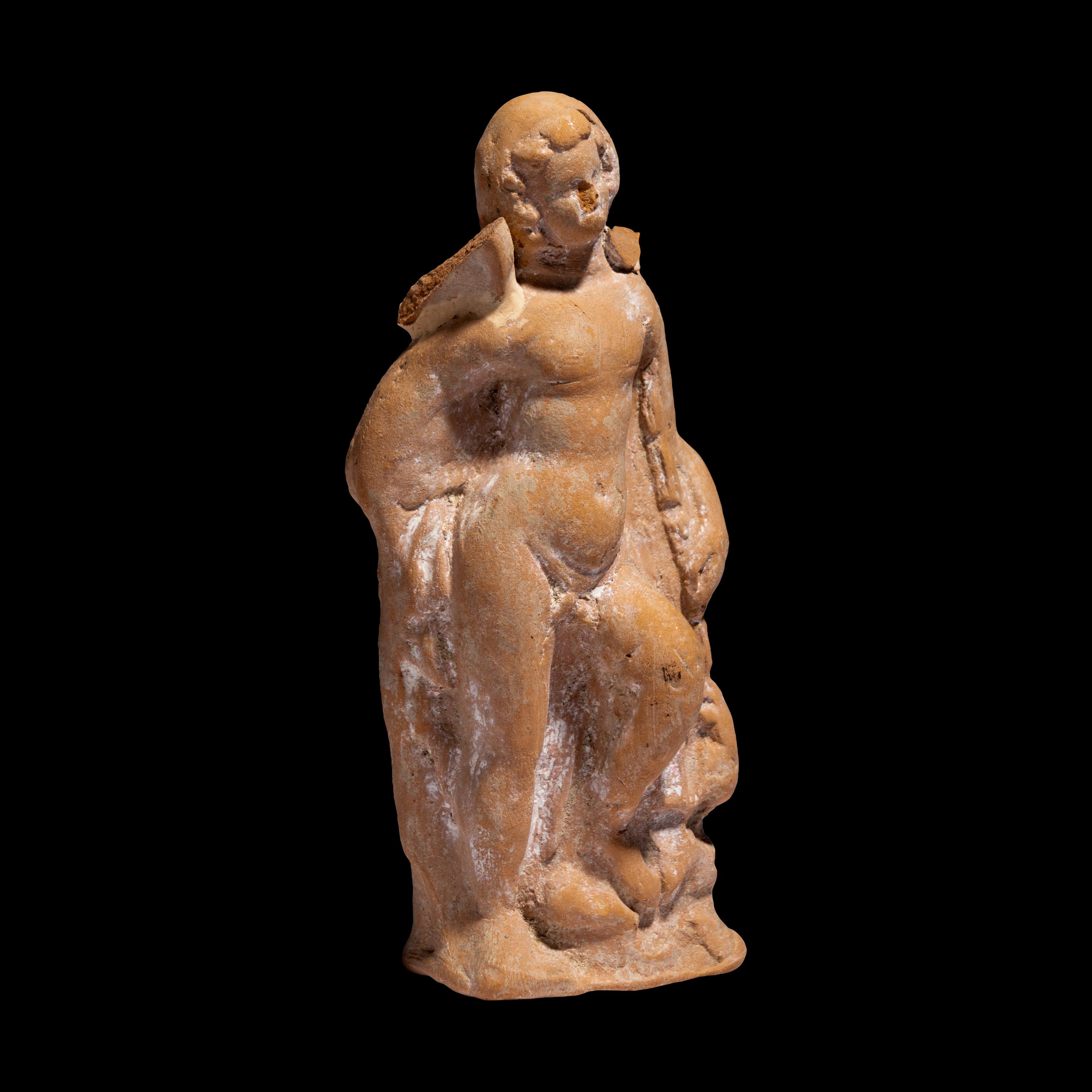A Greek Terracotta Eros Holding a Club