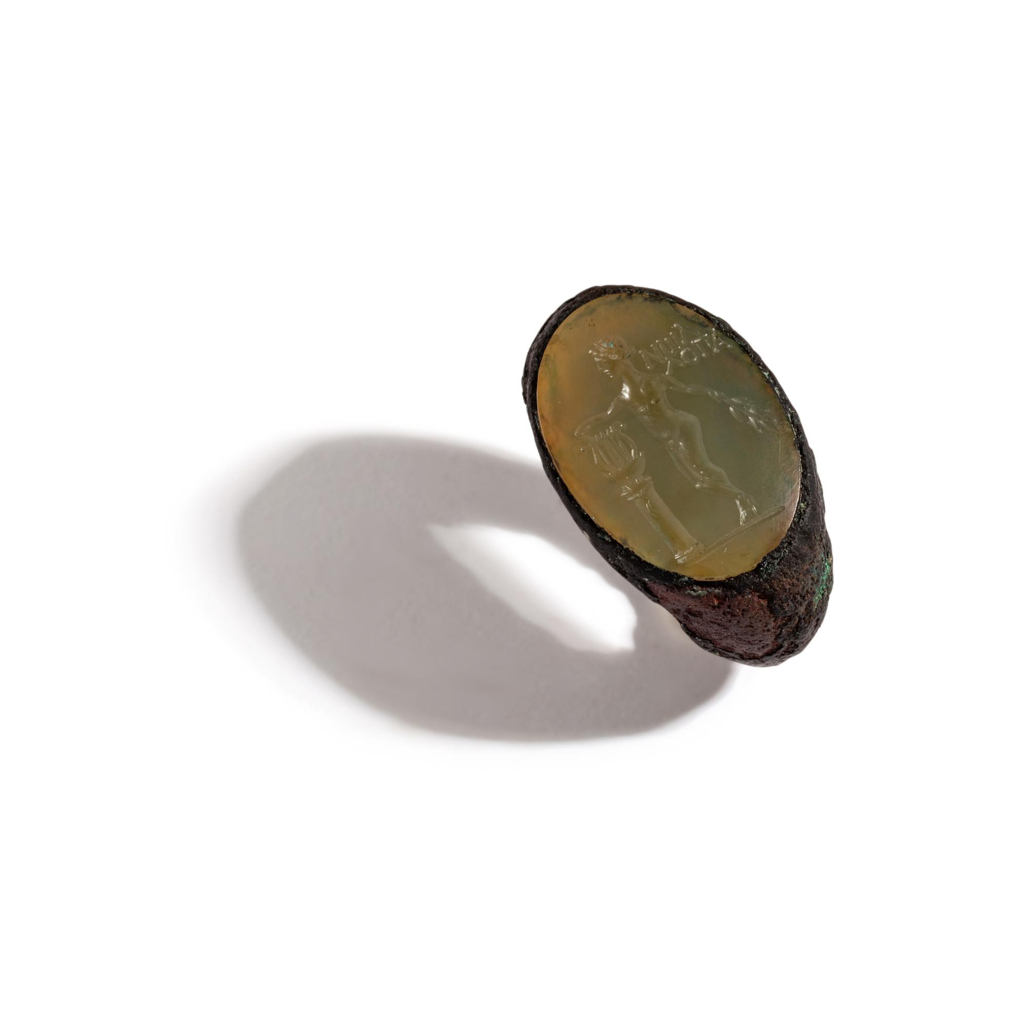 A Roman Copper Alloy and Chalcedony Finger Ring with the God Apollo