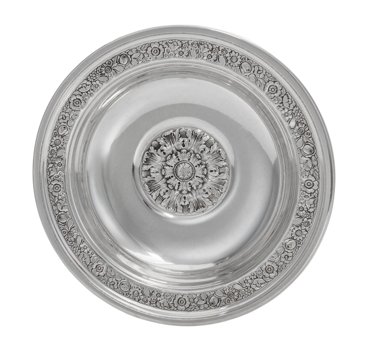 An American Silver Bowl, Reed & Barton, Taunton, MA., 1937, circular, the border chased with dense flowers and foliage, center with a l