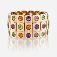 An eighteen karat gold and gem-set bangle