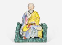 A Chinese famille rose-decorated porcelain figure of a seated lohan 粉彩羅漢坐像