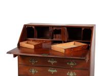 A Chippendale Carved and Figured Mahogany Reverse-Serpentine Claw-and-Ball Foot Slant-Front Desk