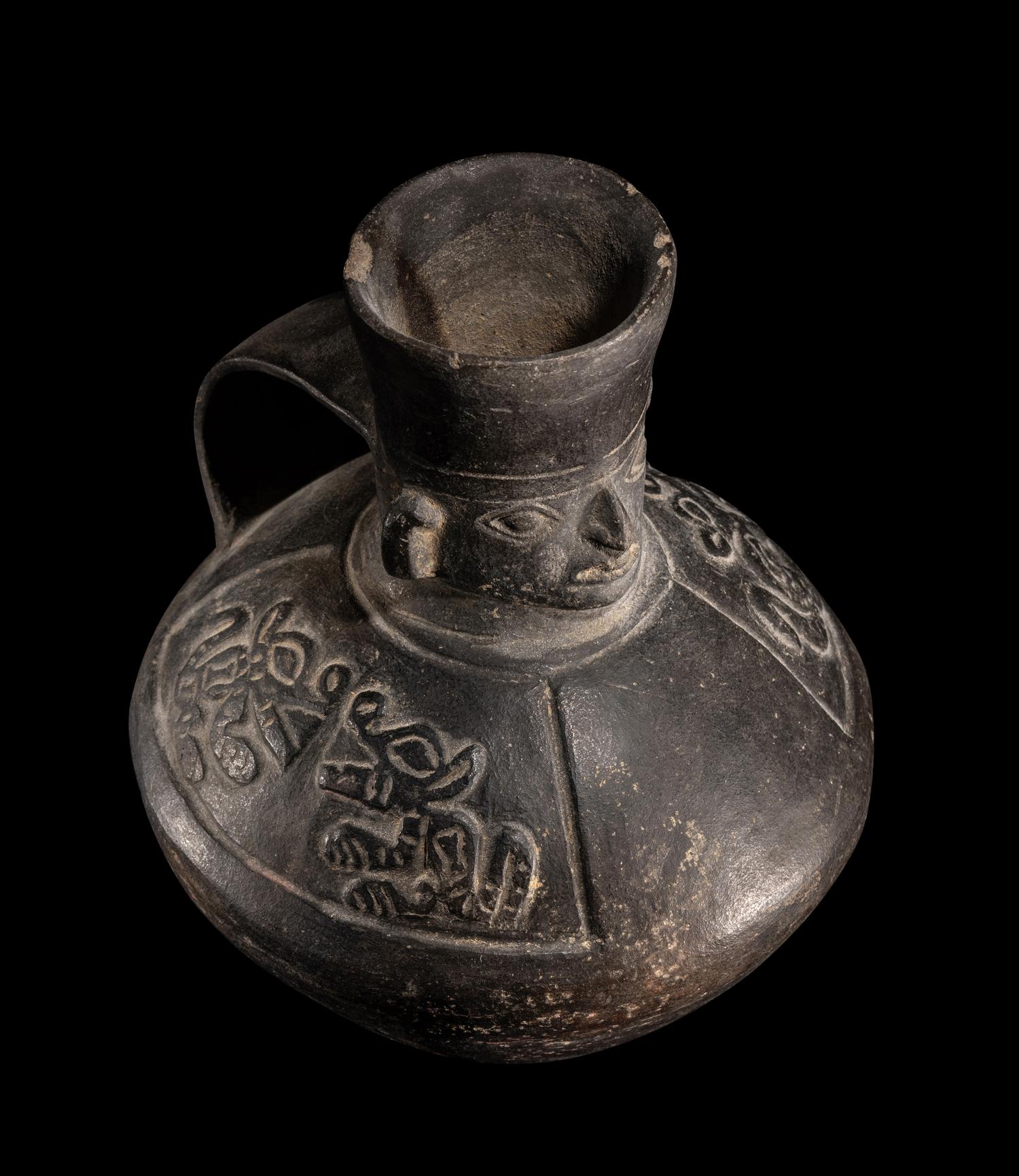 A Chimu Blackware Vessel with Human Face and Animal Motif
