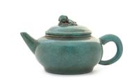 A Green Glazed Yixing Pottery Teapot Height 3 5/8 x width over handle 7 7/8 inches.
