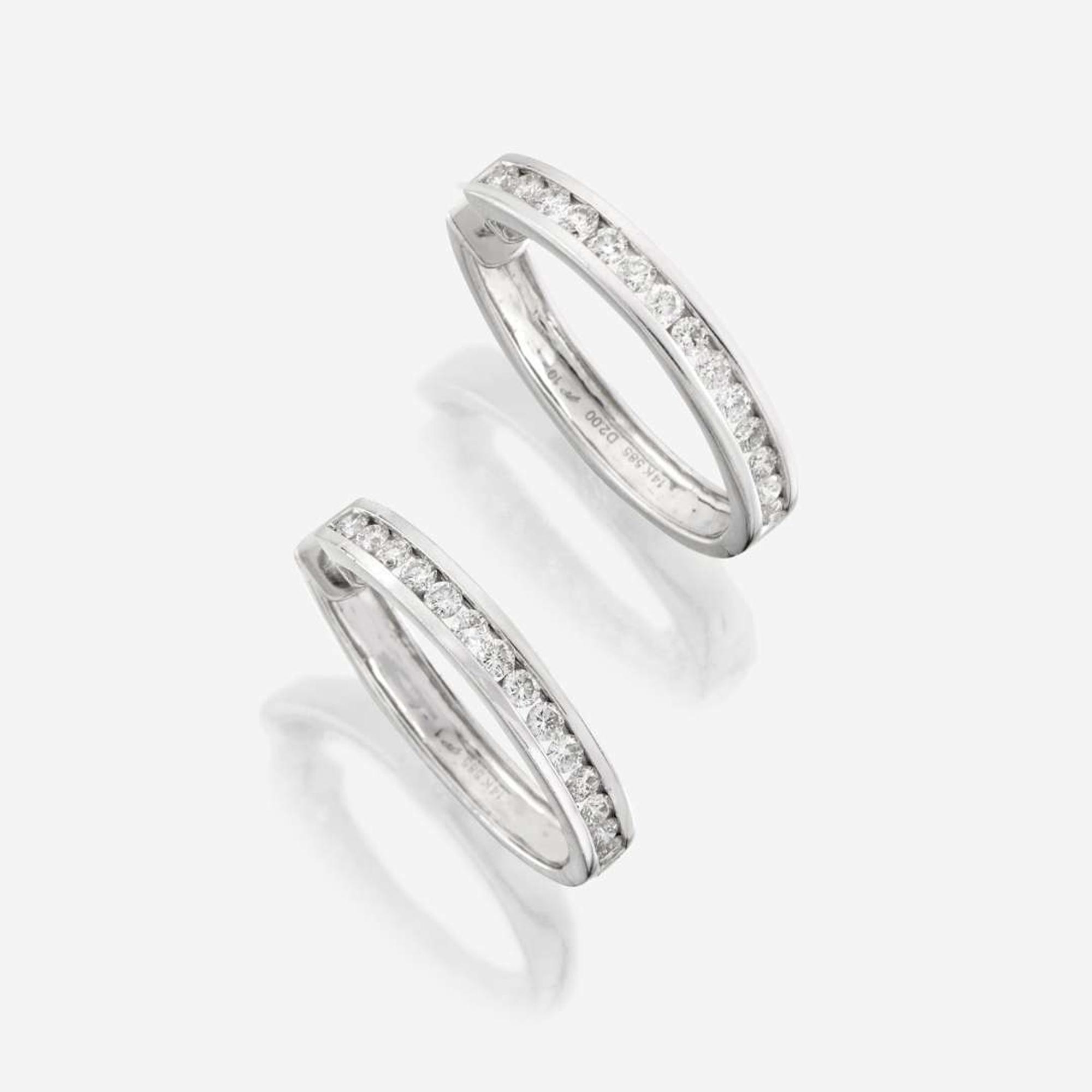 A pair of diamond and fourteen karat white gold earrings