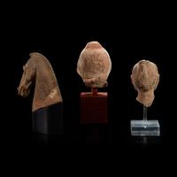Three Chinese pottery heads of two men and a horse Han dynasty and later