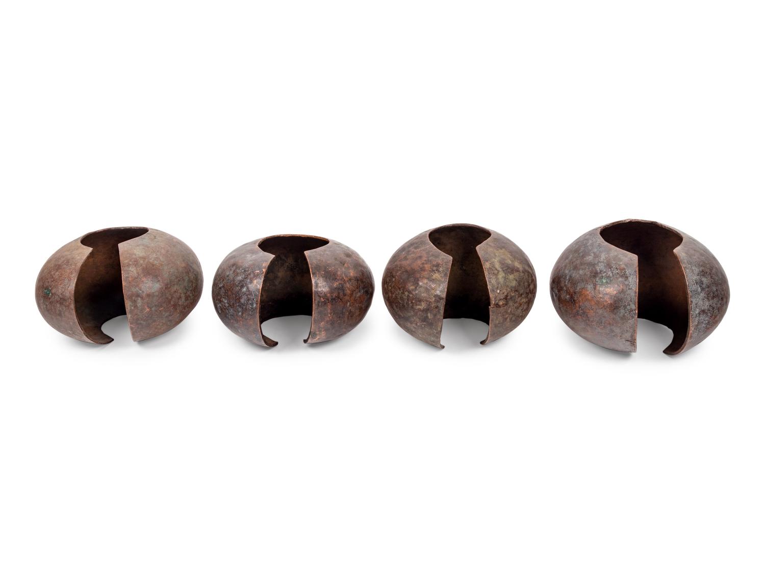 A Pair of Philippine Carved Wood Bowls and Four African Bronze Currency Bracelets on Metal Stands