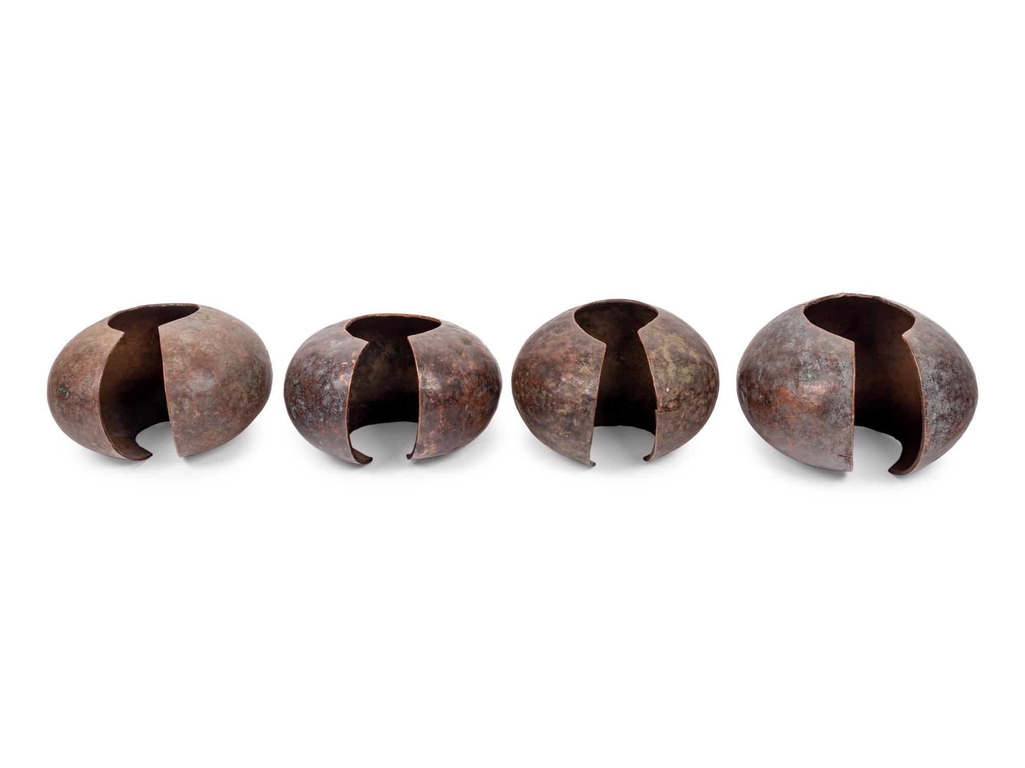 A Pair of Philippine Carved Wood Bowls and Four African Bronze Currency Bracelets on Metal Stands