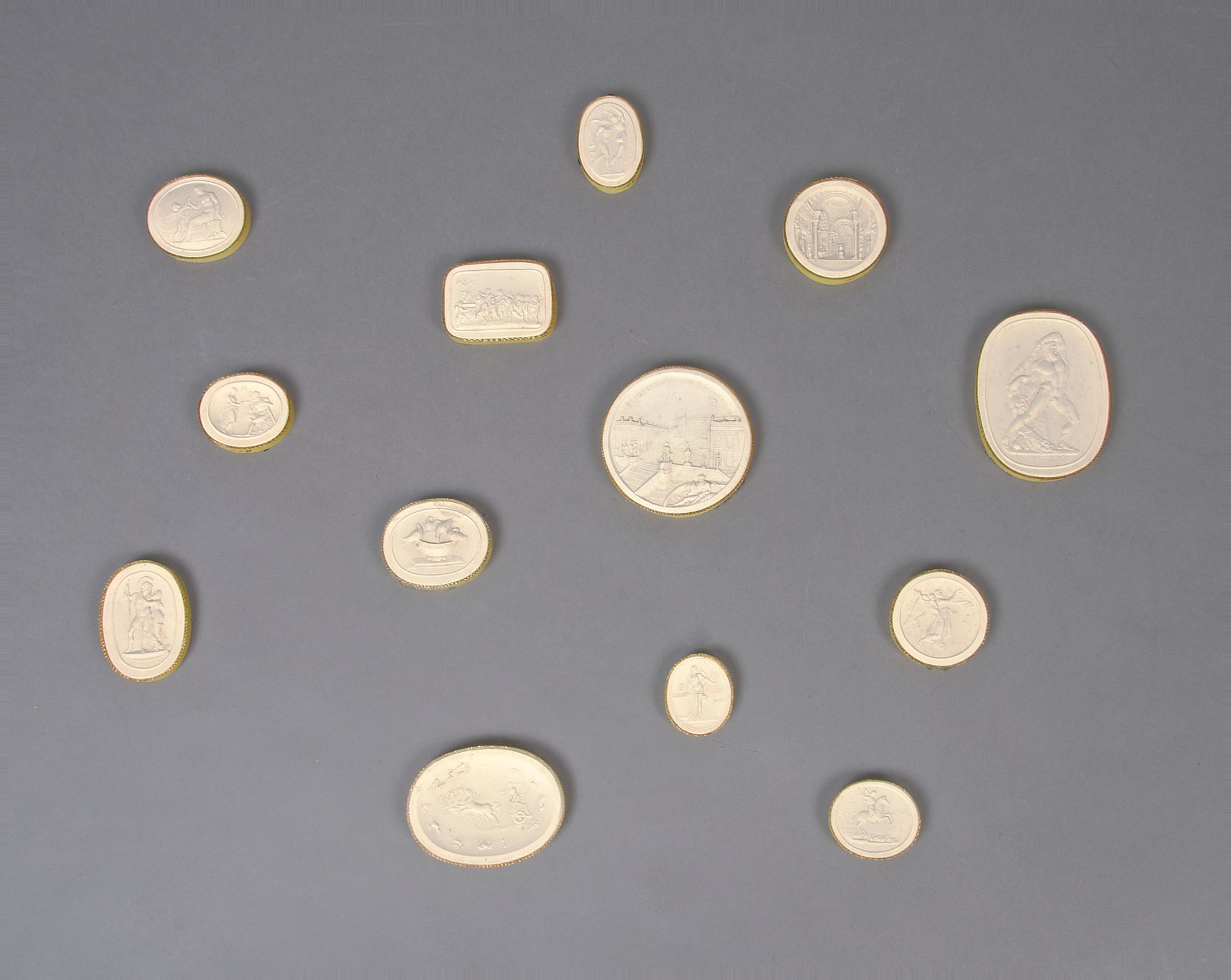 A Collection of Thirteen Plaster Medallions, Height of tallest 3 inches.