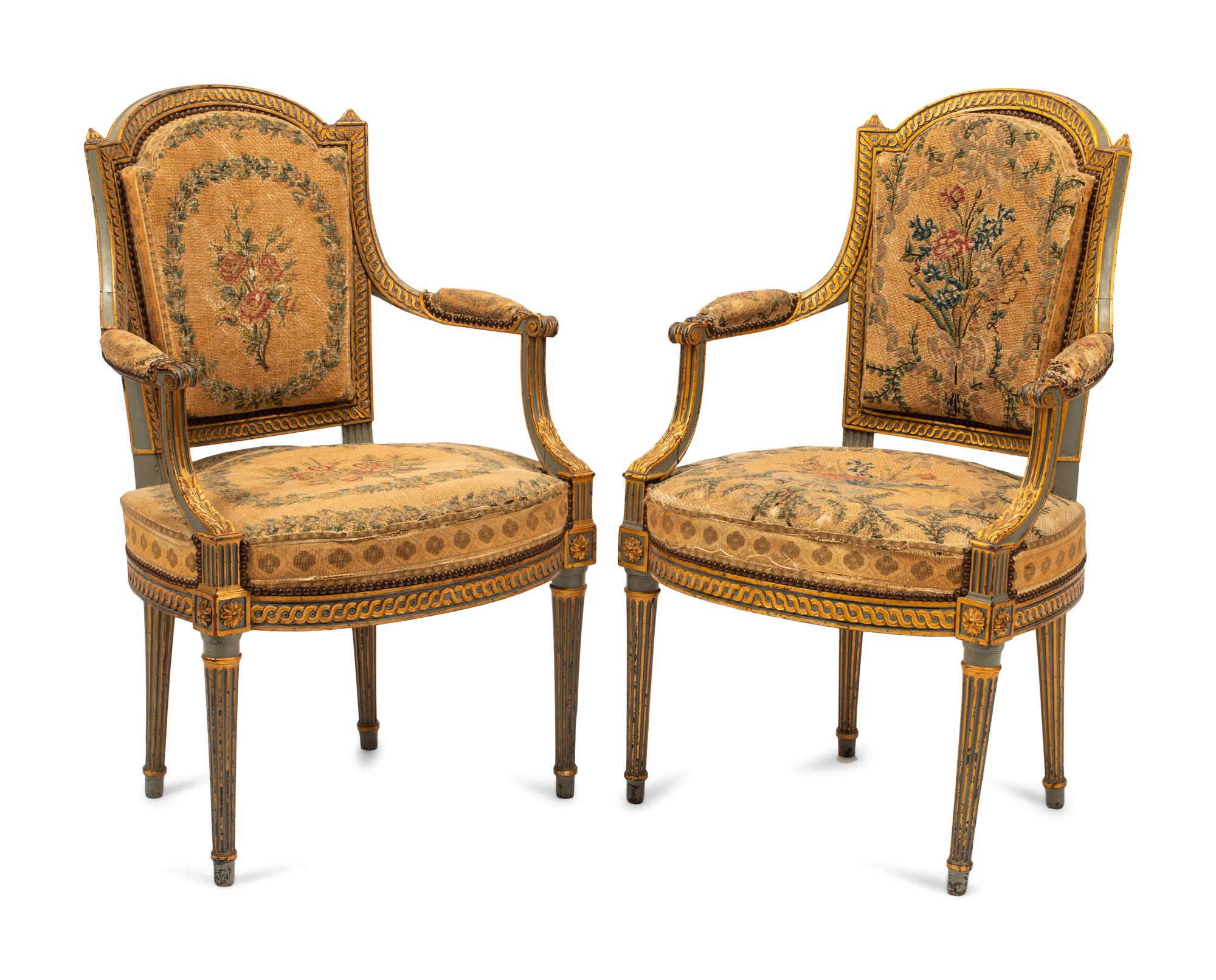 A Pair of French Neoclassical Painted and Parcel Gilt Armchairs