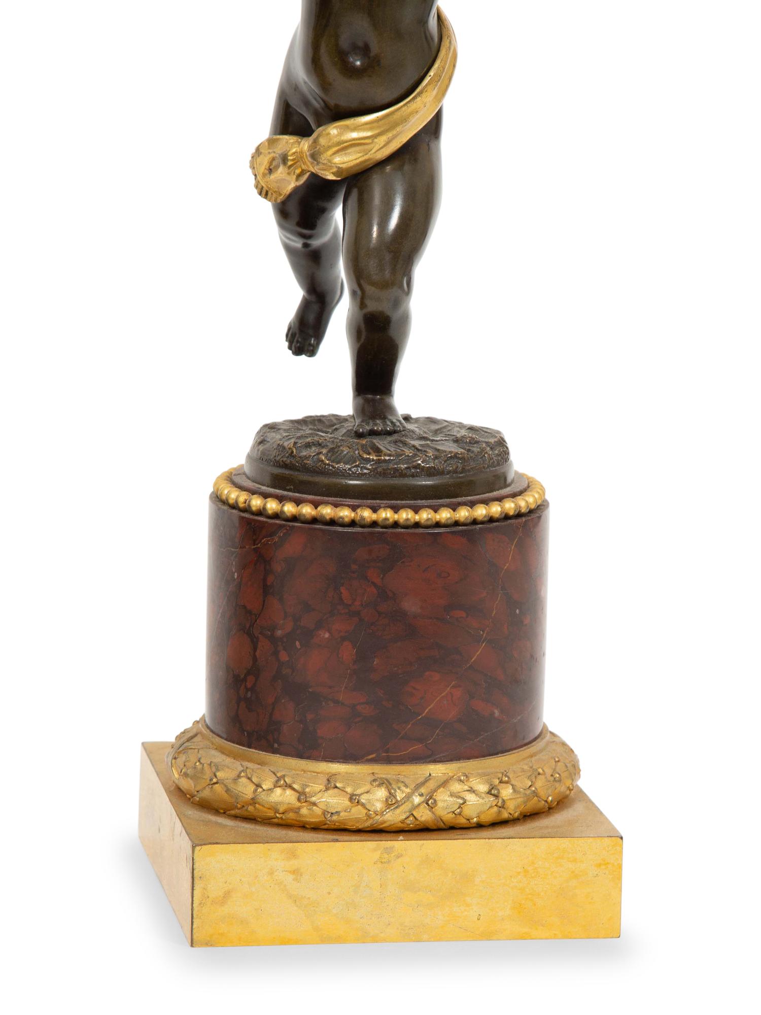 A French Gilt and Patinated Bronze and Rouge Marble Clock Garniture