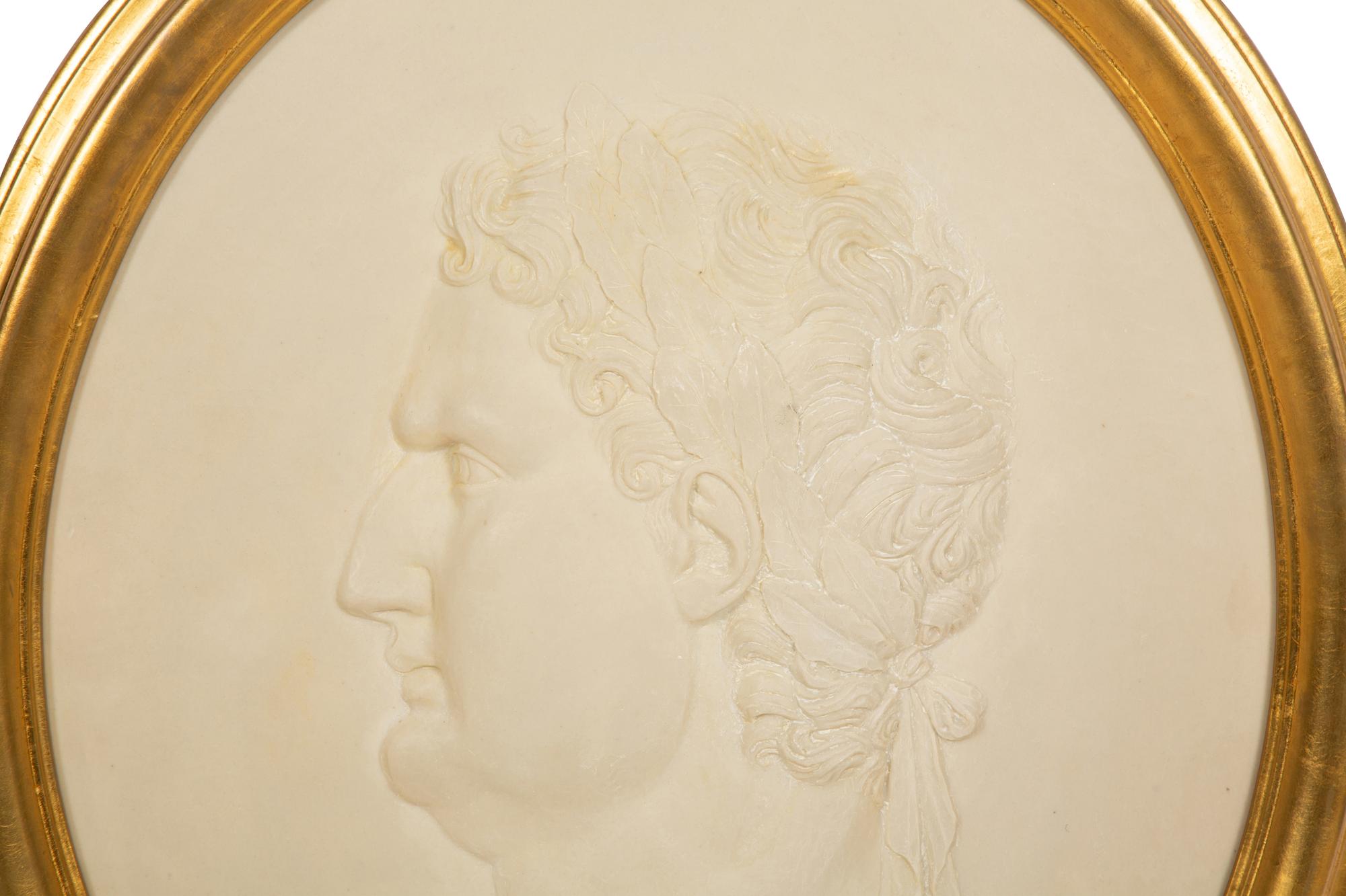 A Pair of Roman Style Composition Relief Plaques in Giltwood Frames